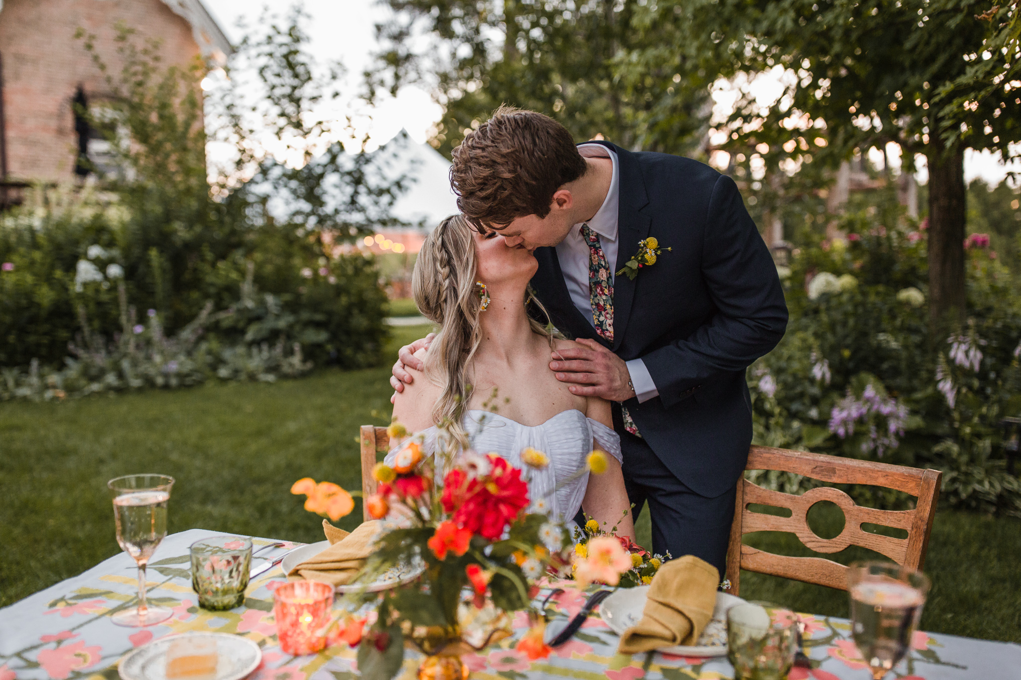 Milwaukee bride and groom kissing at table decorated by Bloom Lovely Farms