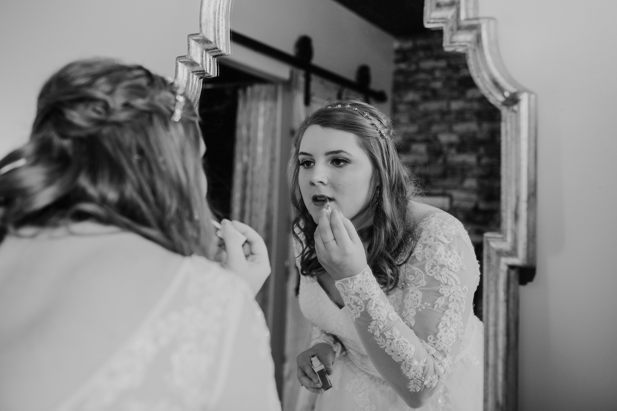 Bride putting on lipstick in the mirror