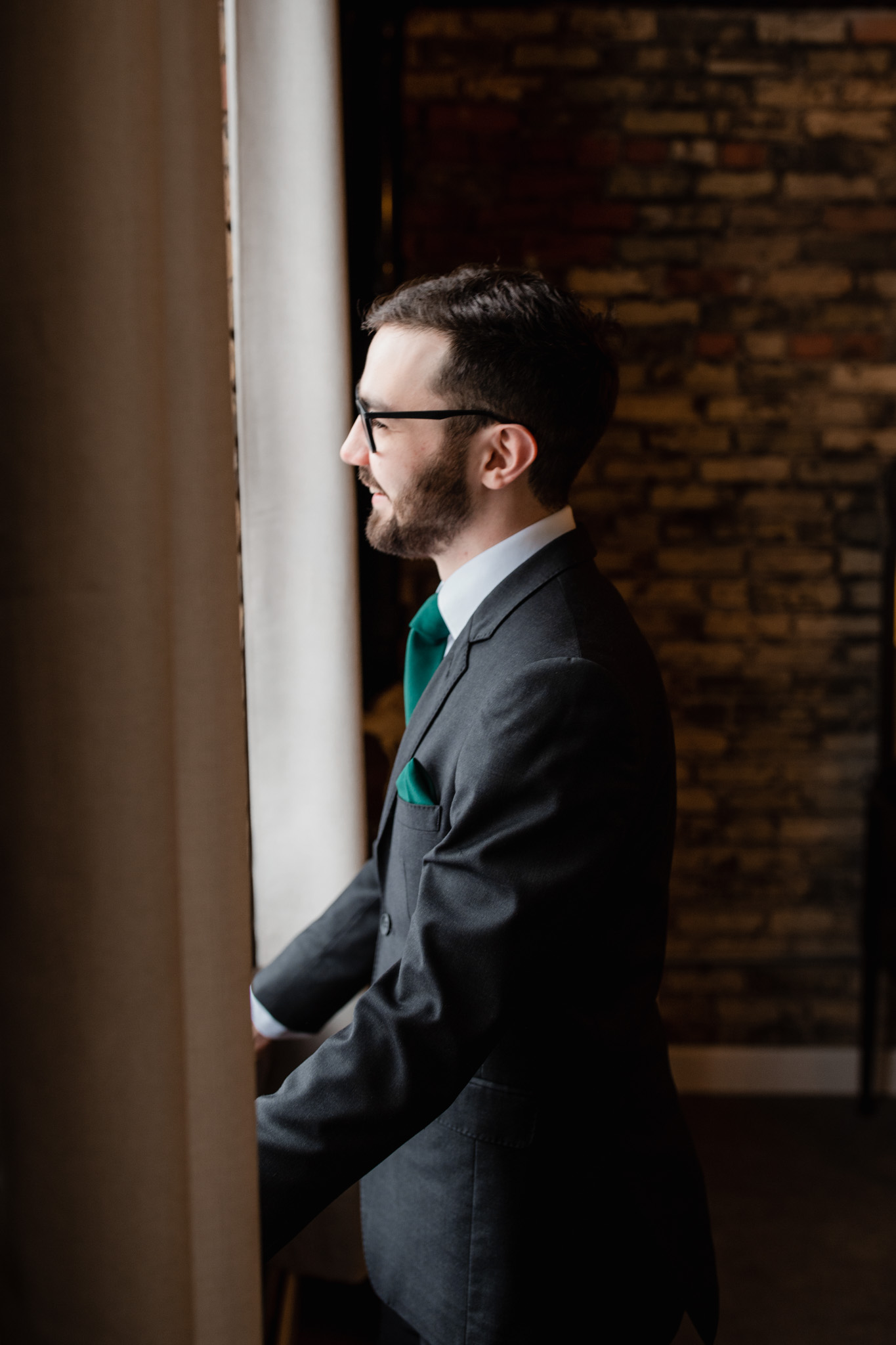 Groom standing in a window