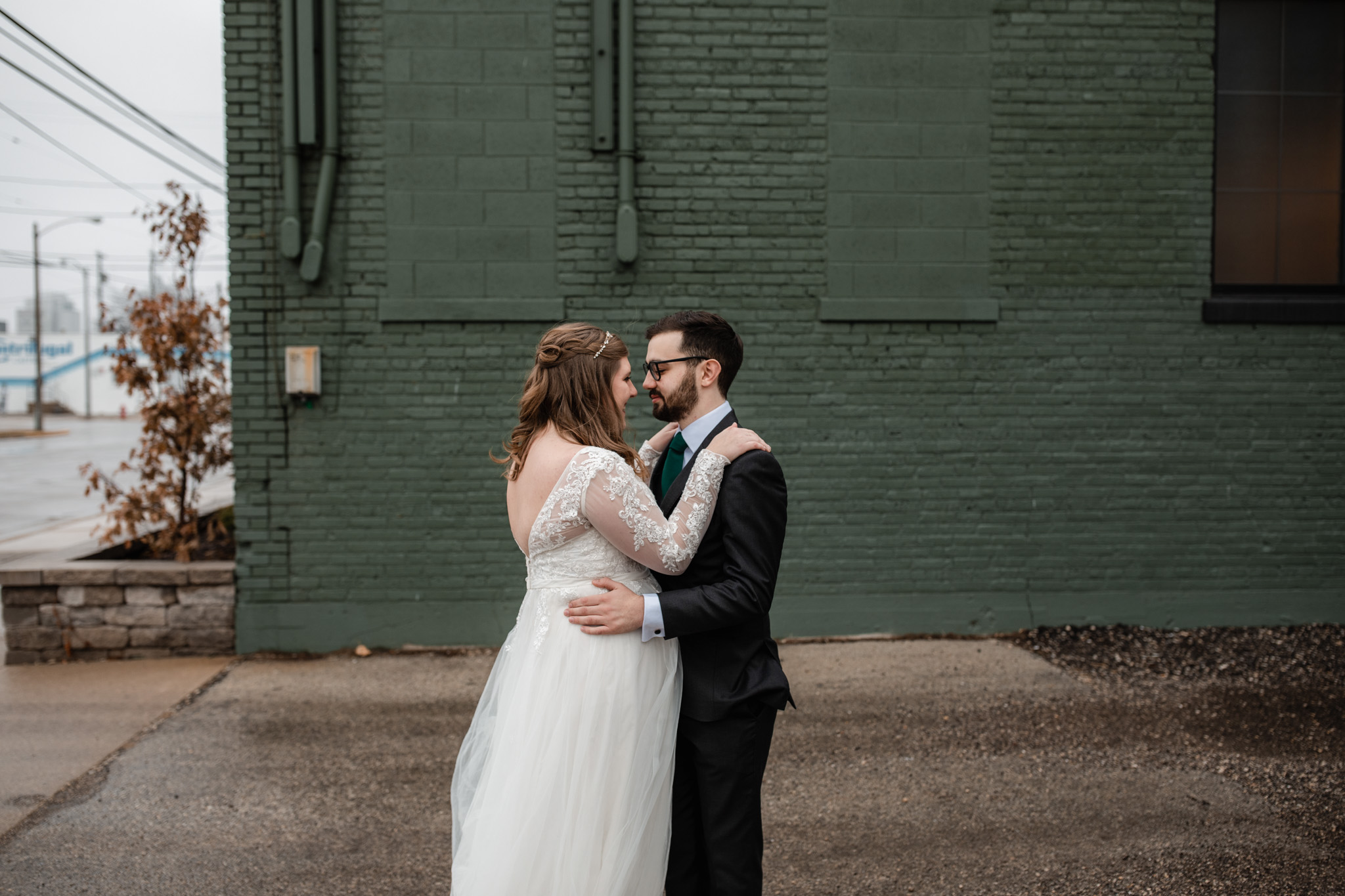 bride groom in front of milwaukee ivy house green wall