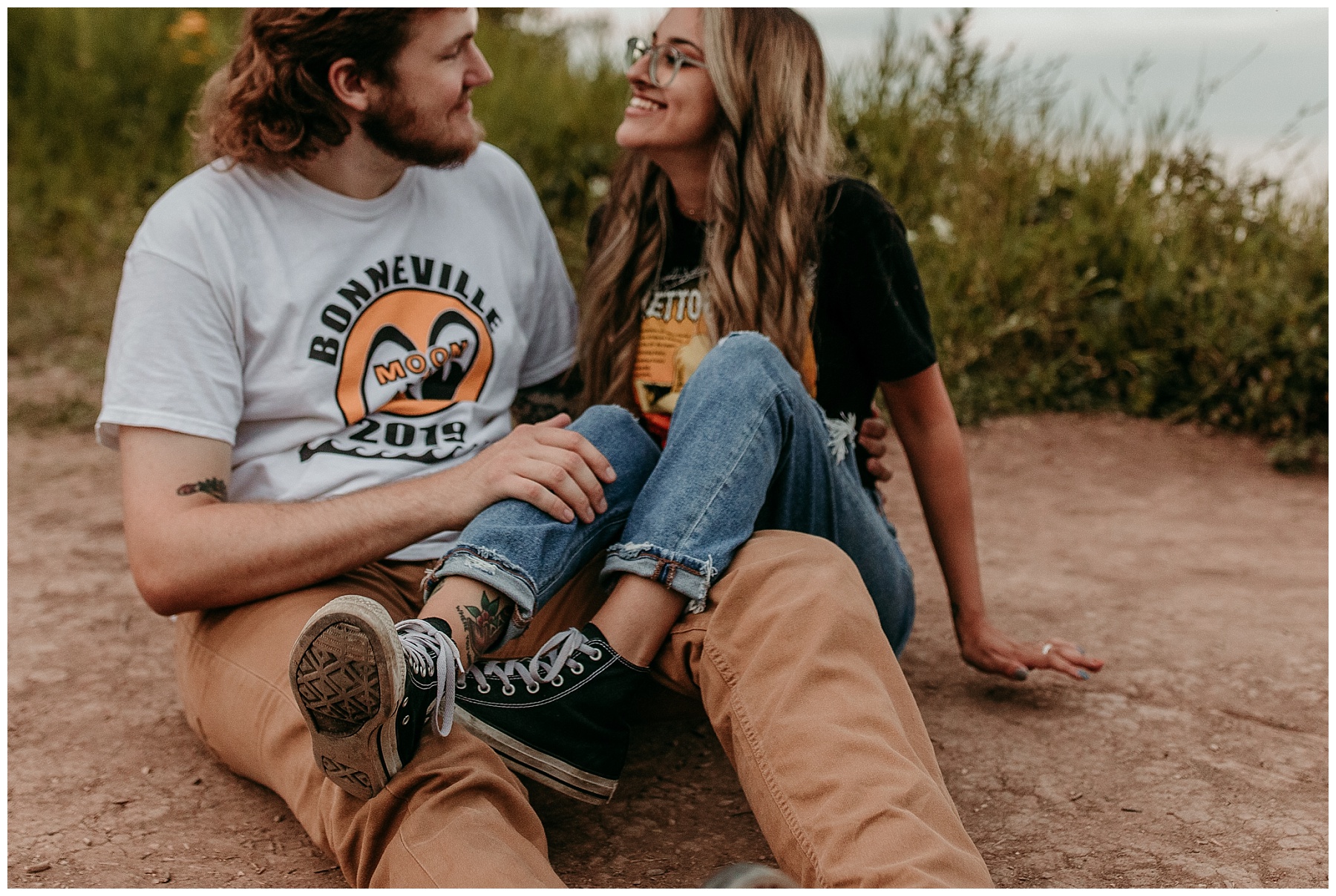 couple wearing graphic tees and vans for their engagement session on a bluff in grafton wisconsin at lions den park