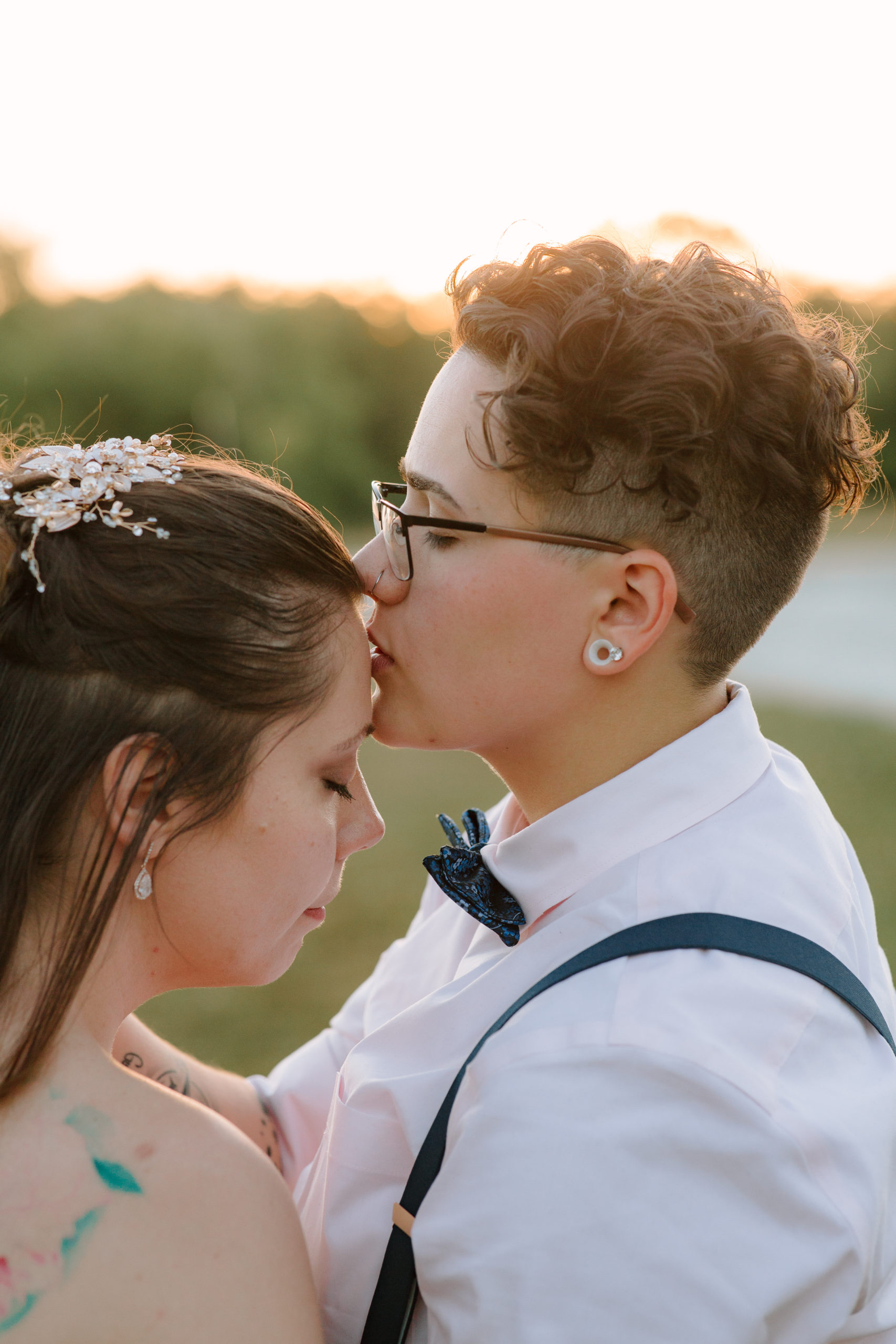 Two brides in a field taking sunset pictures
