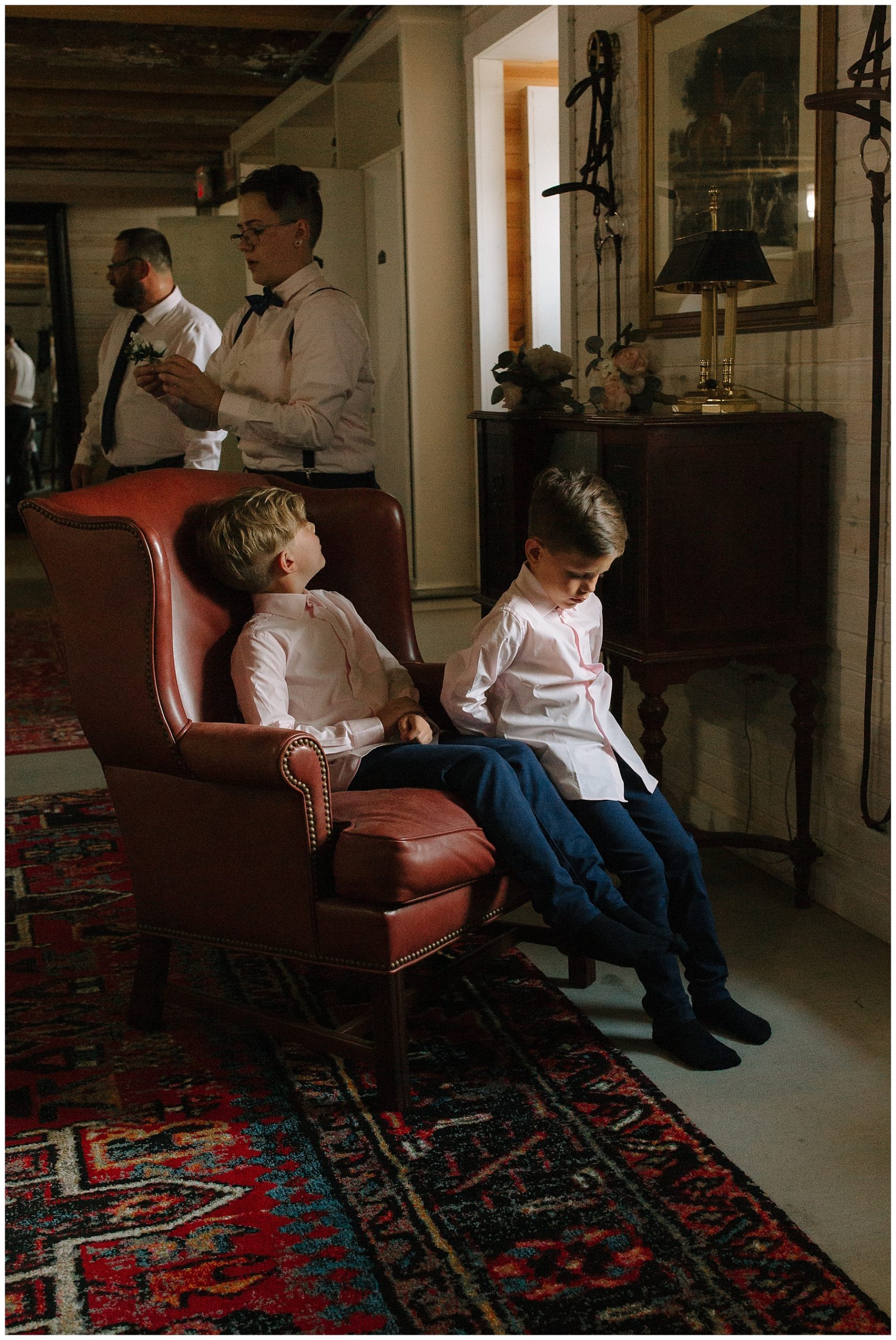 Bride's two sweet sons sitting in a chair waiting for the wedding to start