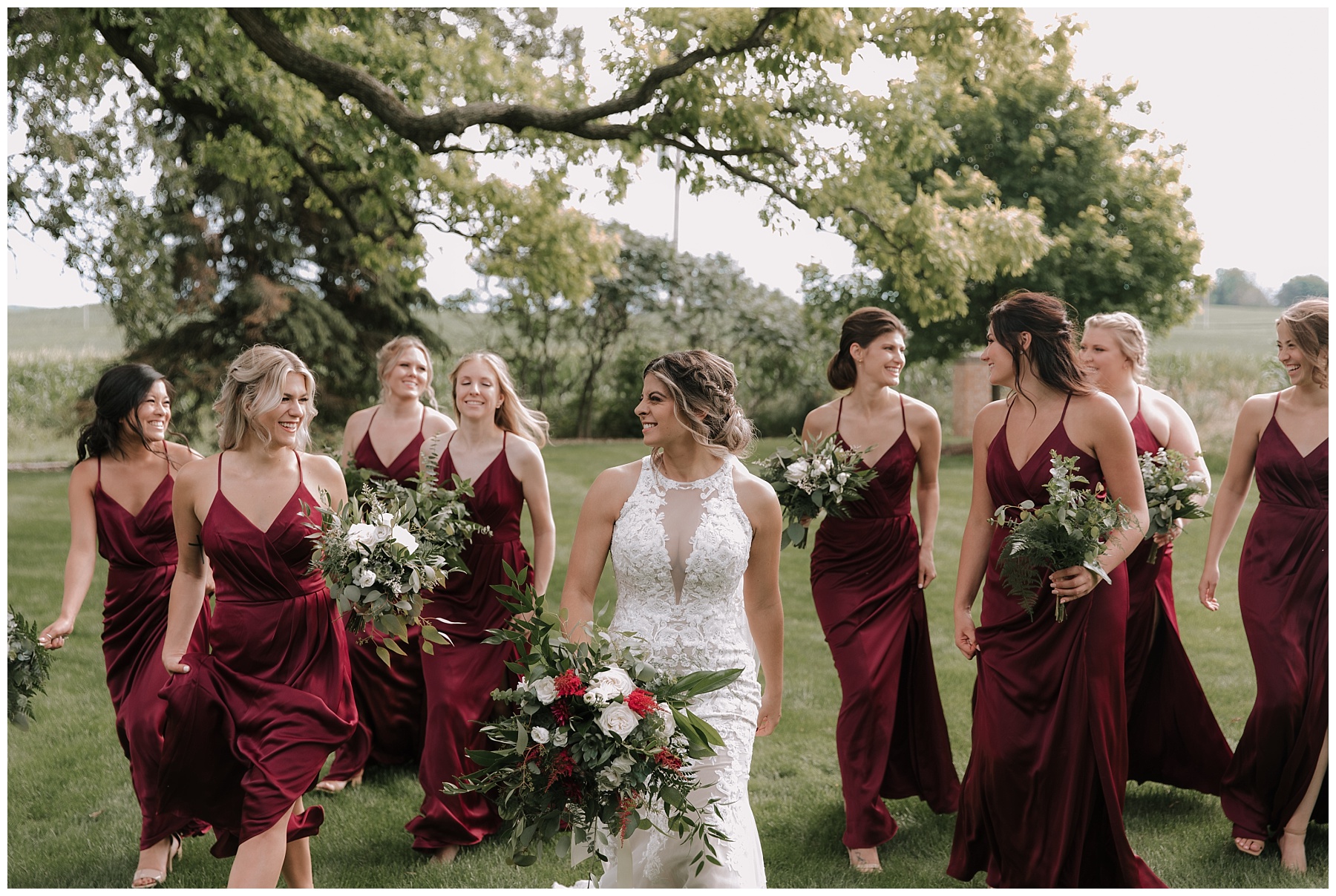 Bride and bridesmaids walking through grass