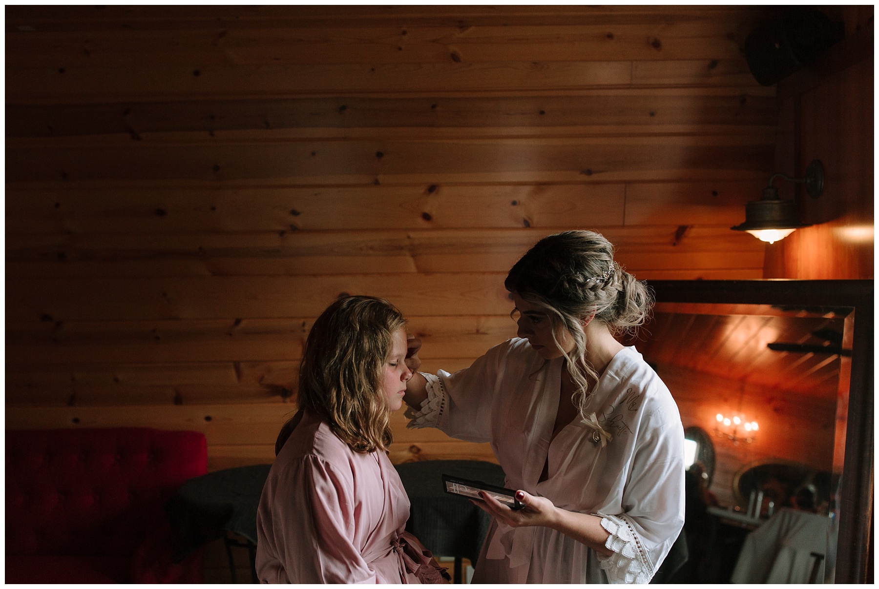 Bride doing sister's makeup before wedding in Wisconsin with Nirav Patel style framing.