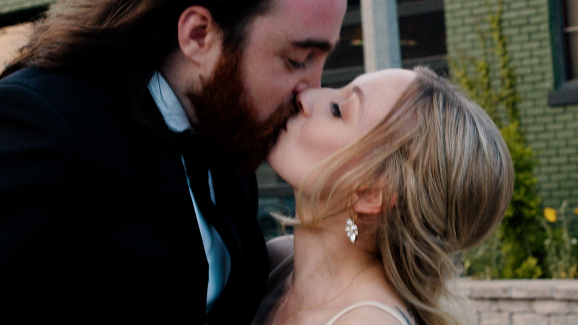Couple kissing in front of Milwaukee wedding venue The Ivy House
