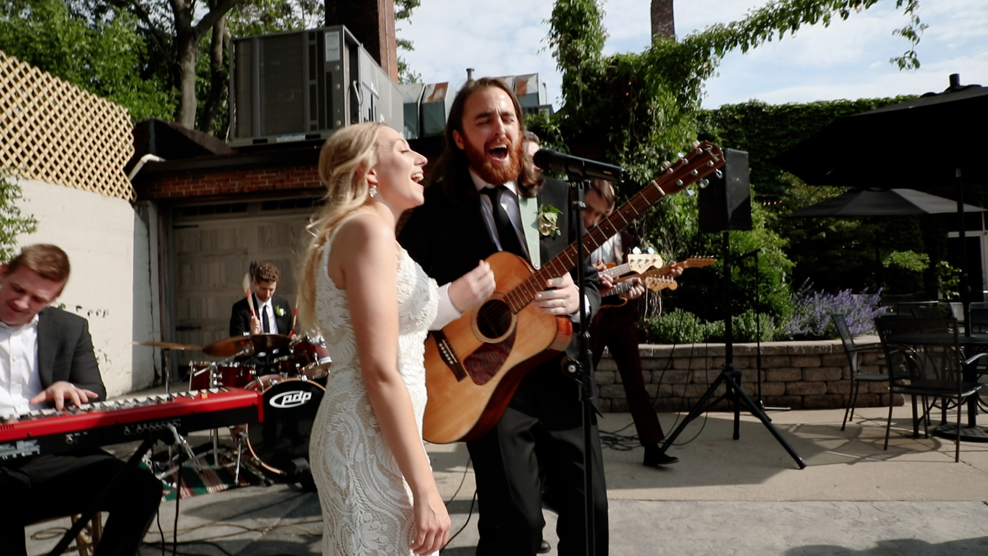 Upbeat couple performing at their wedding ceremony playing guitar and singing - The Ivy House Milwaukee