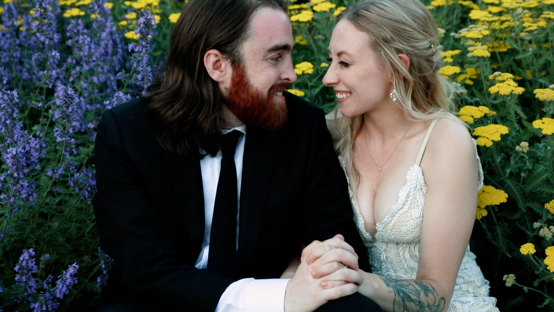 Upbeat couples portrait in flower field outside of the Ivy House in Milwaukee