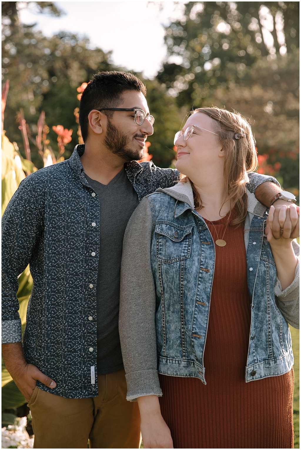 Man and woman wearing glasses with blue and orange engagement session outfits