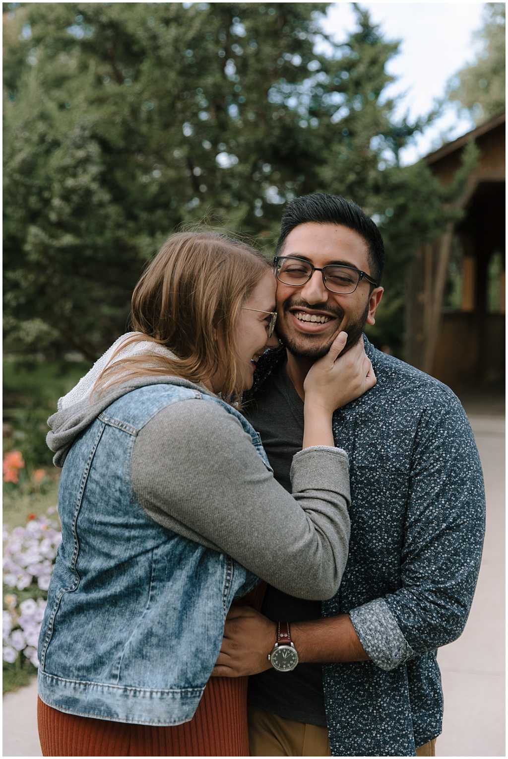 Sweet engagement photo with woman holding man's neck and laughing with their faces together