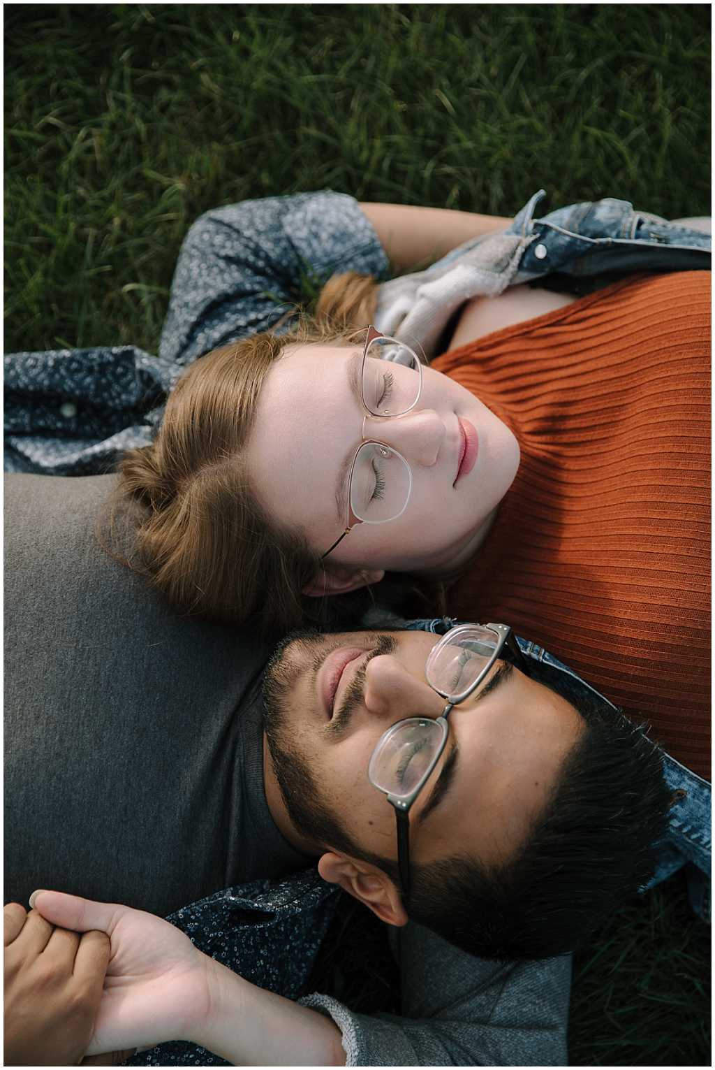 man and woman of different skin tones laying side by side, resting heads on each others shoulders