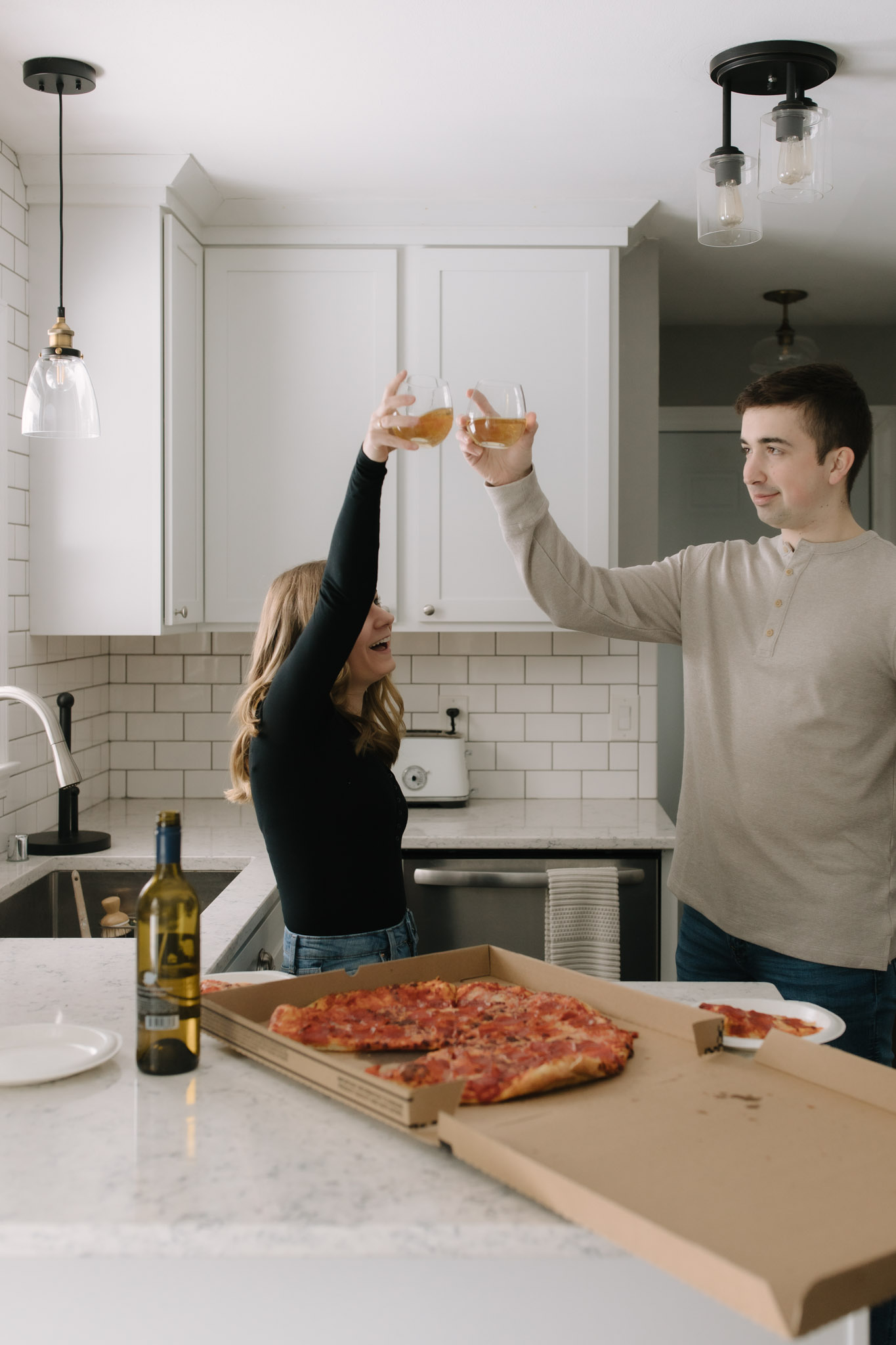 Couple raising a glass of wine to celebrate their new home in a photoshoot