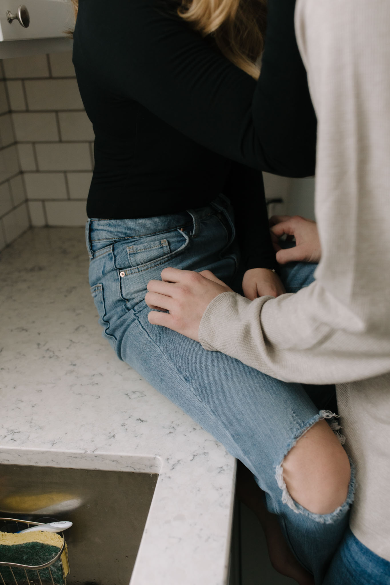 Couple sitting on the kitchen counter for photos