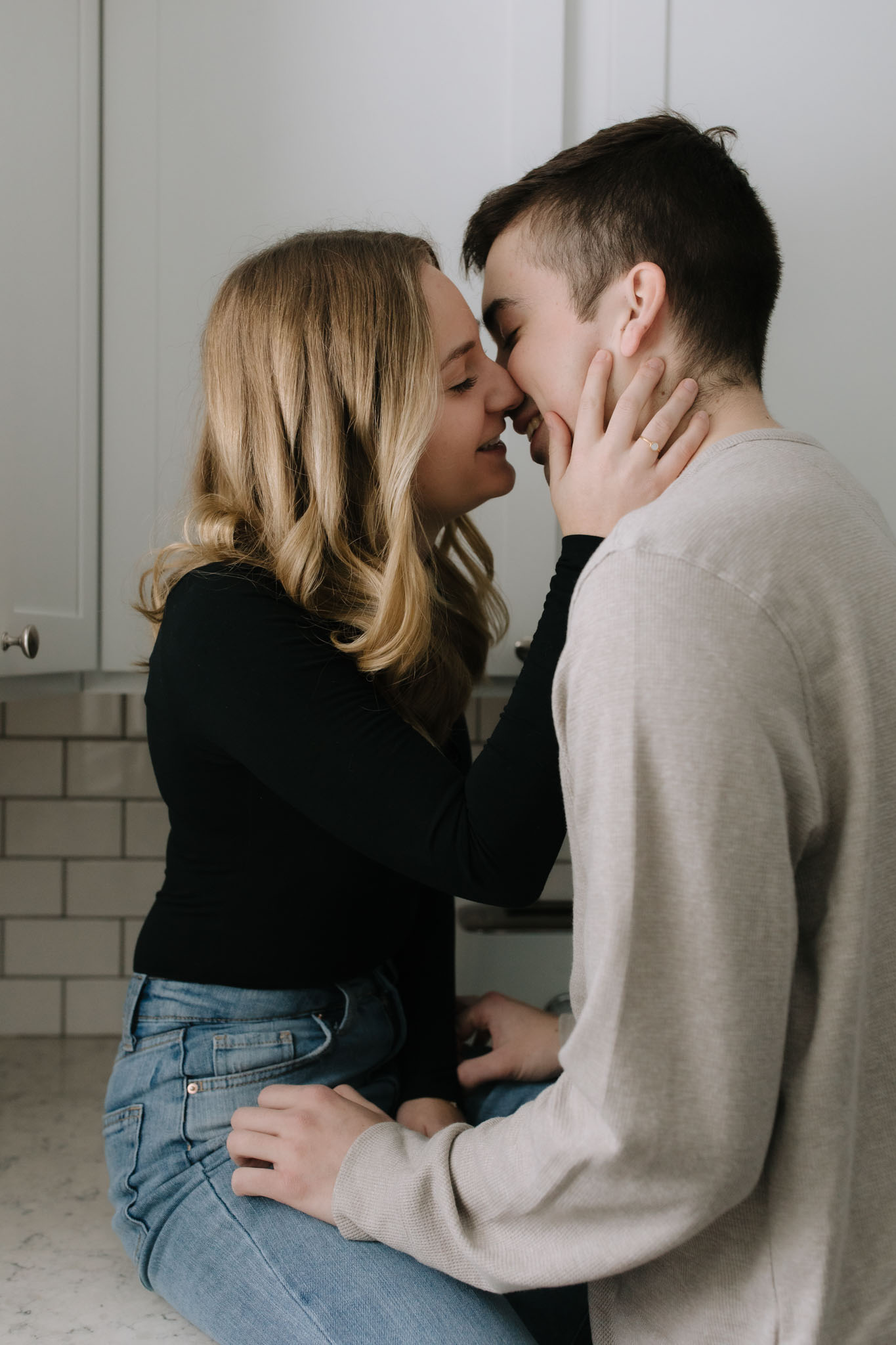 Close up photo of couple kissing on the kitchen counter of their new Port Washington home for a new home photo session