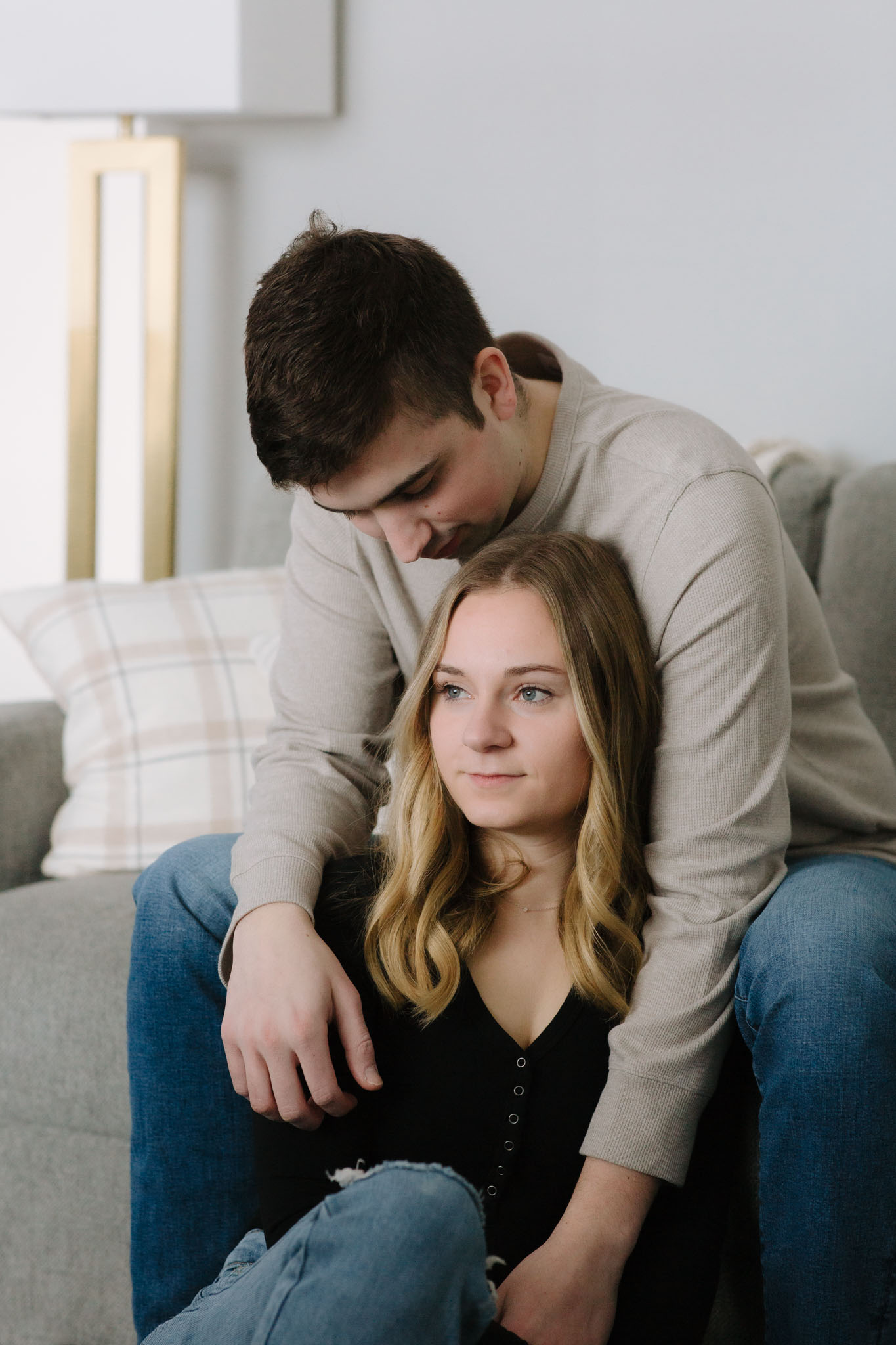 Moody picture of couple sitting int he living room for engagement pictures