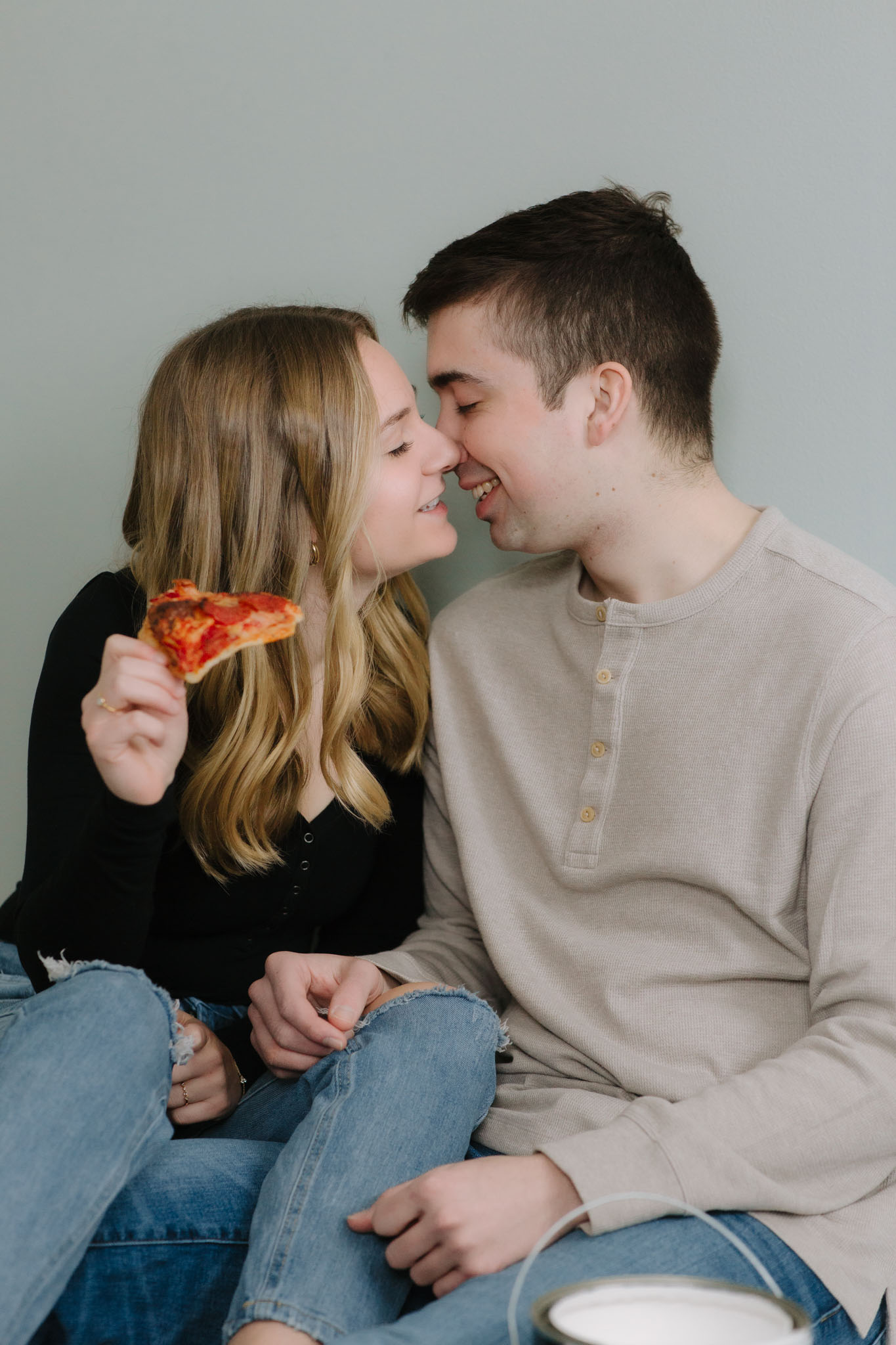 Couple eating pizza on the floor of their new house