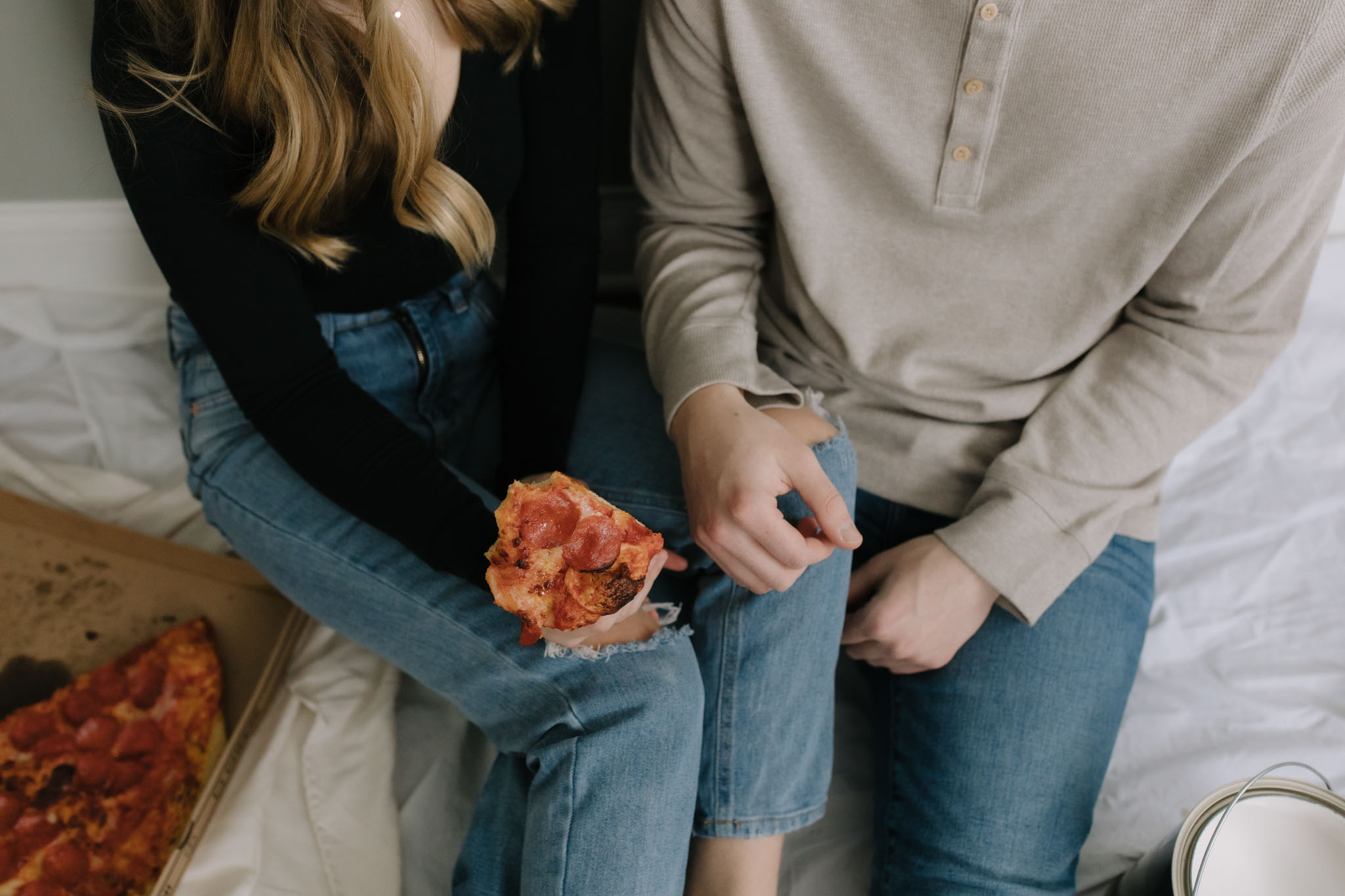 Couple eating pizza on the floor while painting their new house - New home photoshoot