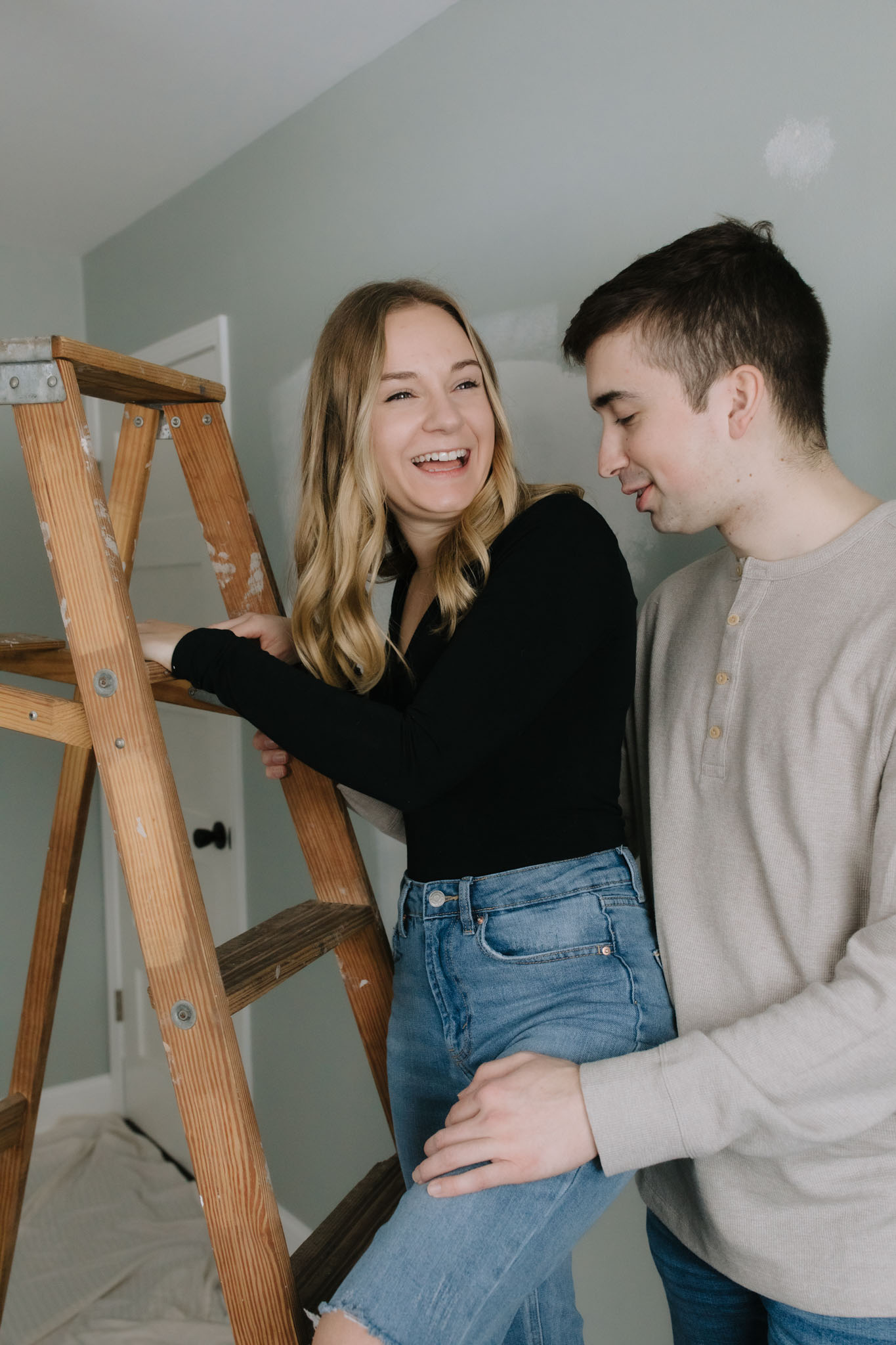Couple standing on ladder for engagement pictures - creative engagement couples portraits