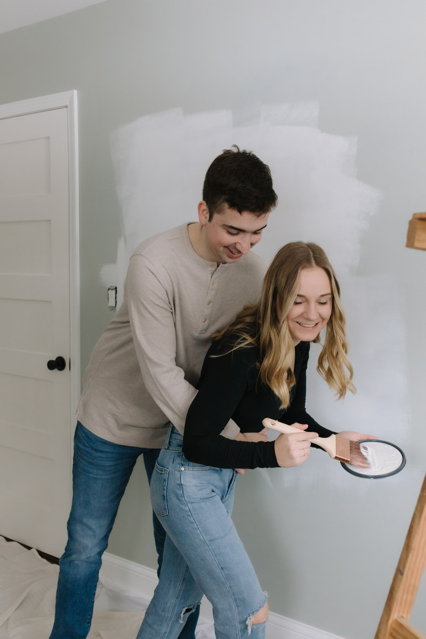 Couple play fighting with paint as they paint their walls
