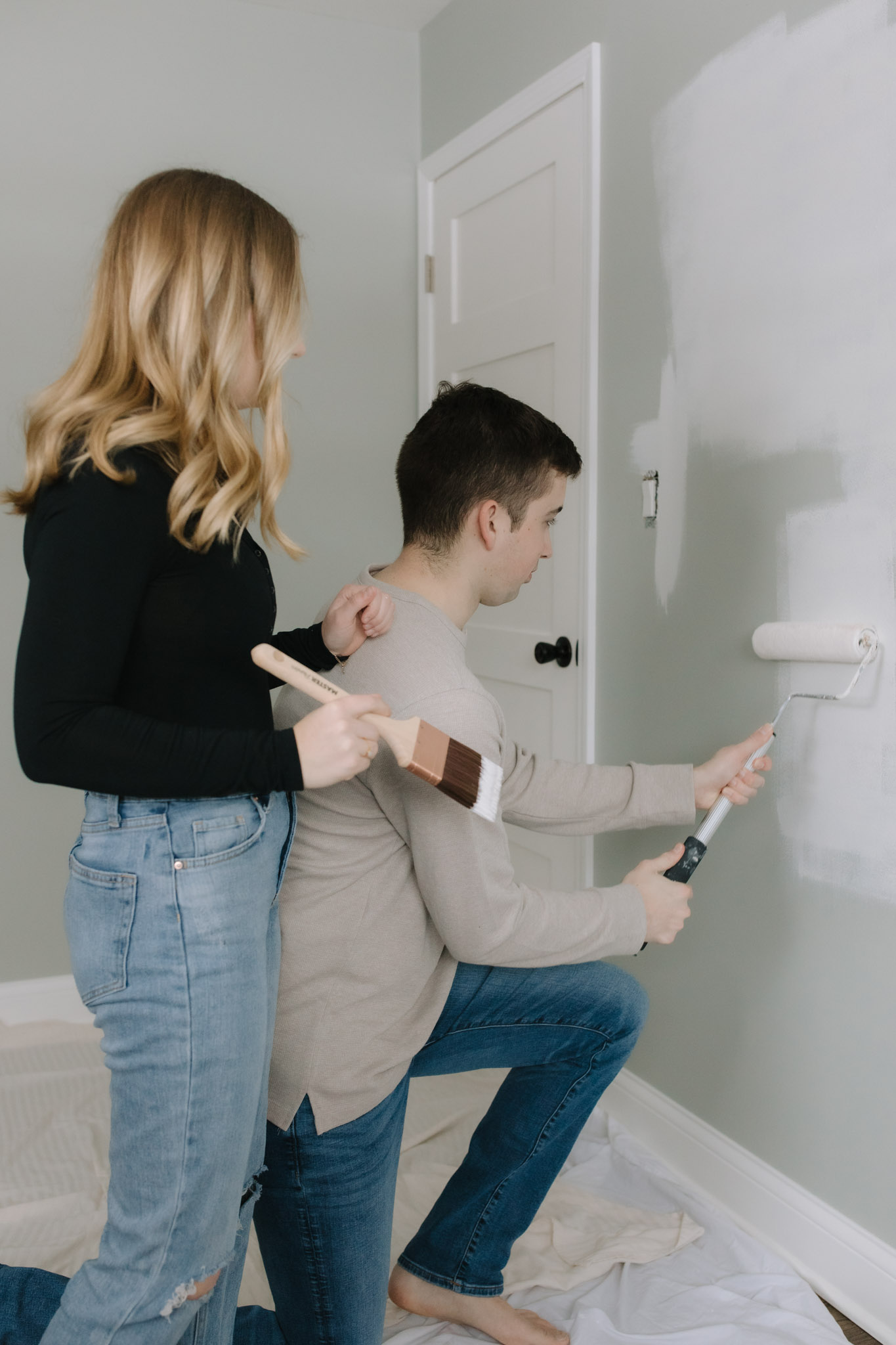 Couple painting the bedroom together