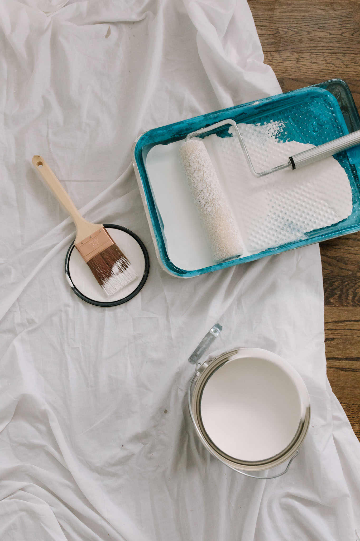 Paint can, roller, and brush with white paint