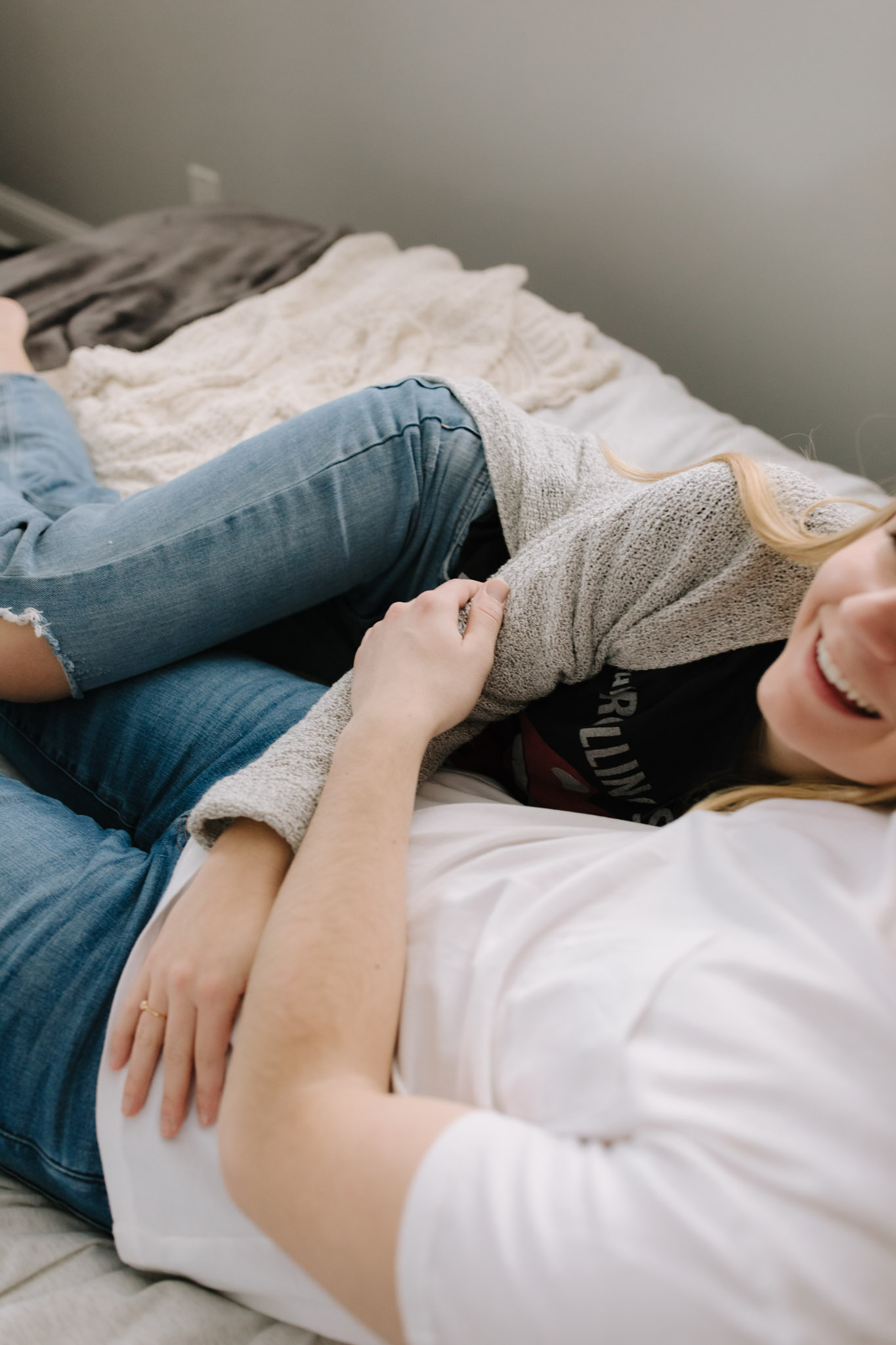 Couple cuddled in bed for in-home engagement pictures