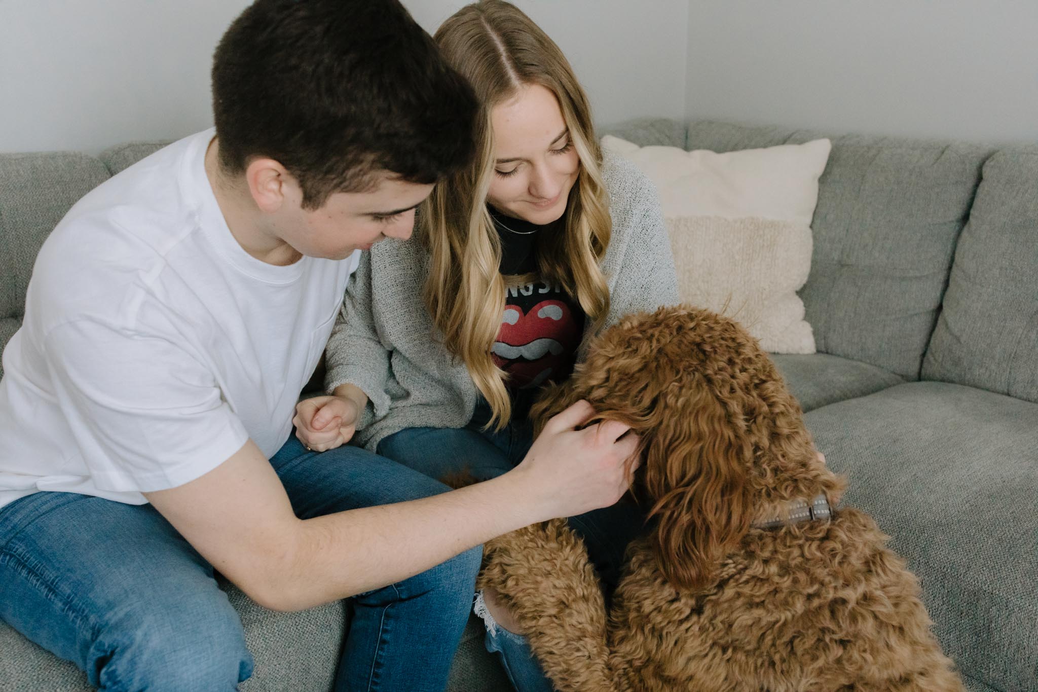 Couple and Goldendoodle dog in home engagement pictures - new home photo session