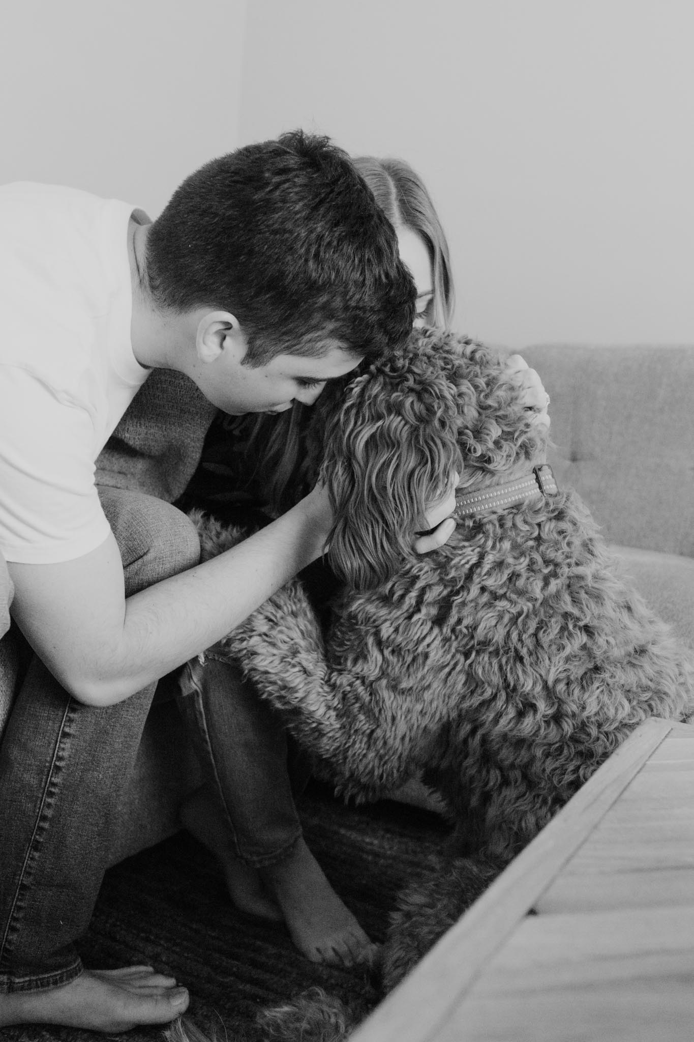 Couple and Goldendoodle dog in home engagement pictures - new home photo session