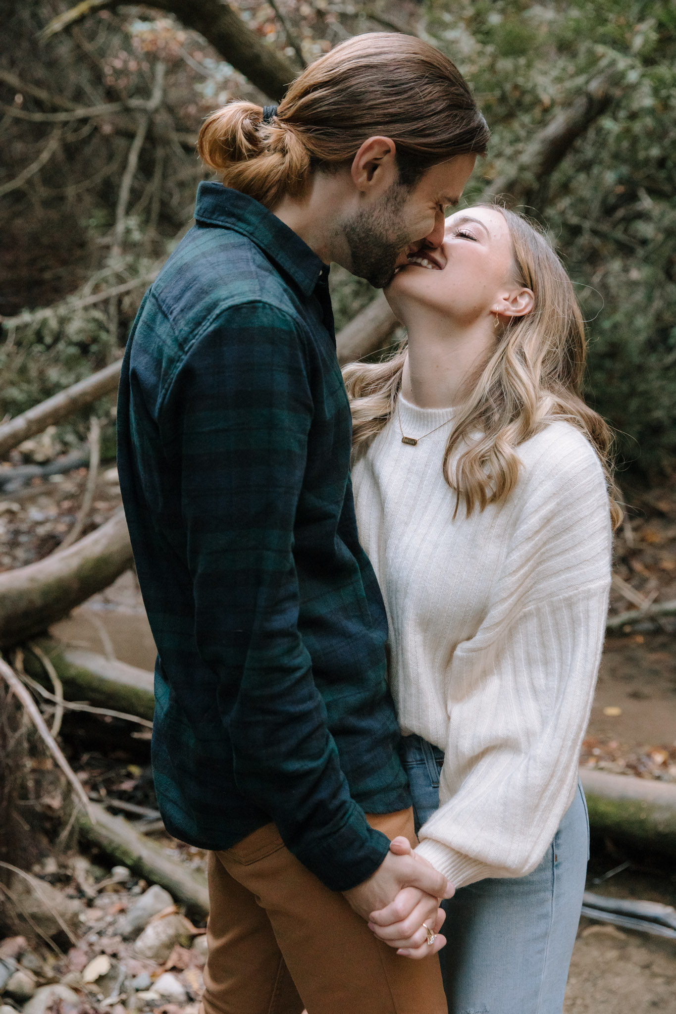 Couple kissing with their teeth during their playful wisconsin engagement session