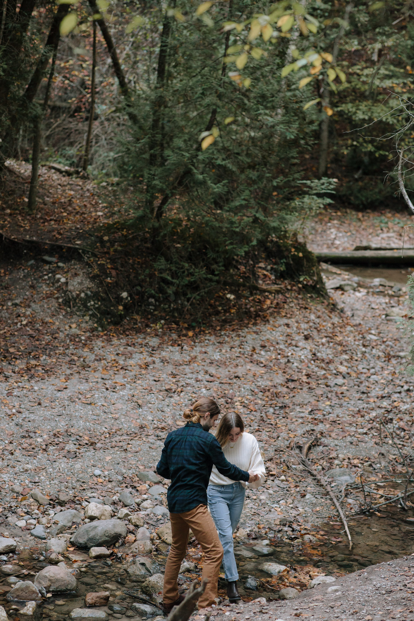 Movement based Adventurous Milwaukee engagement session - climbing across a creek