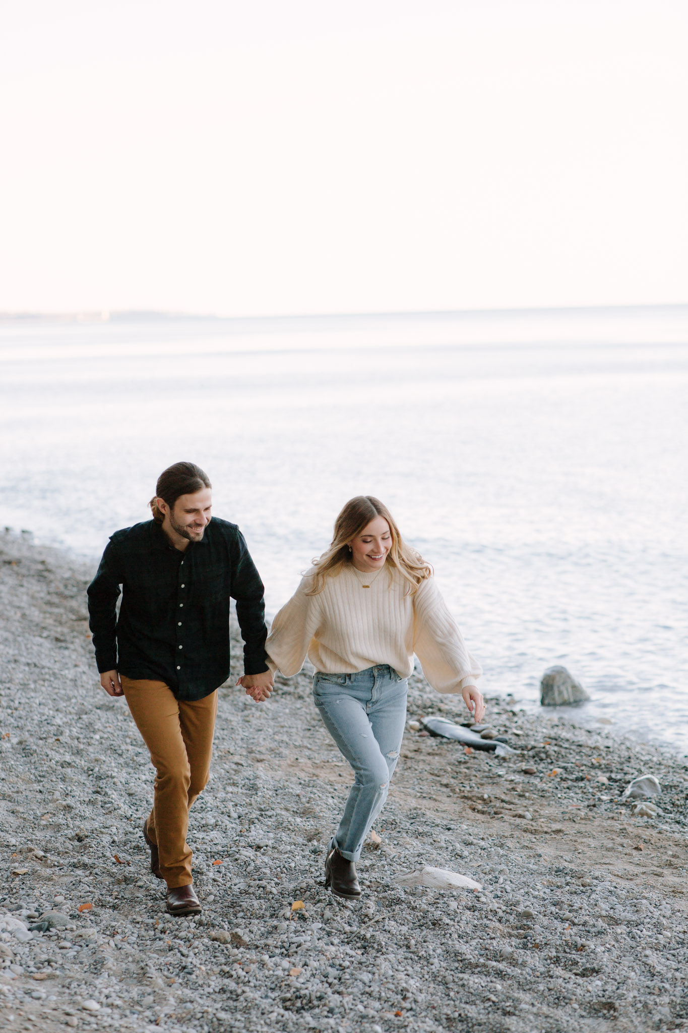 Milwaukee couple running along lake Michigan for engagement photos