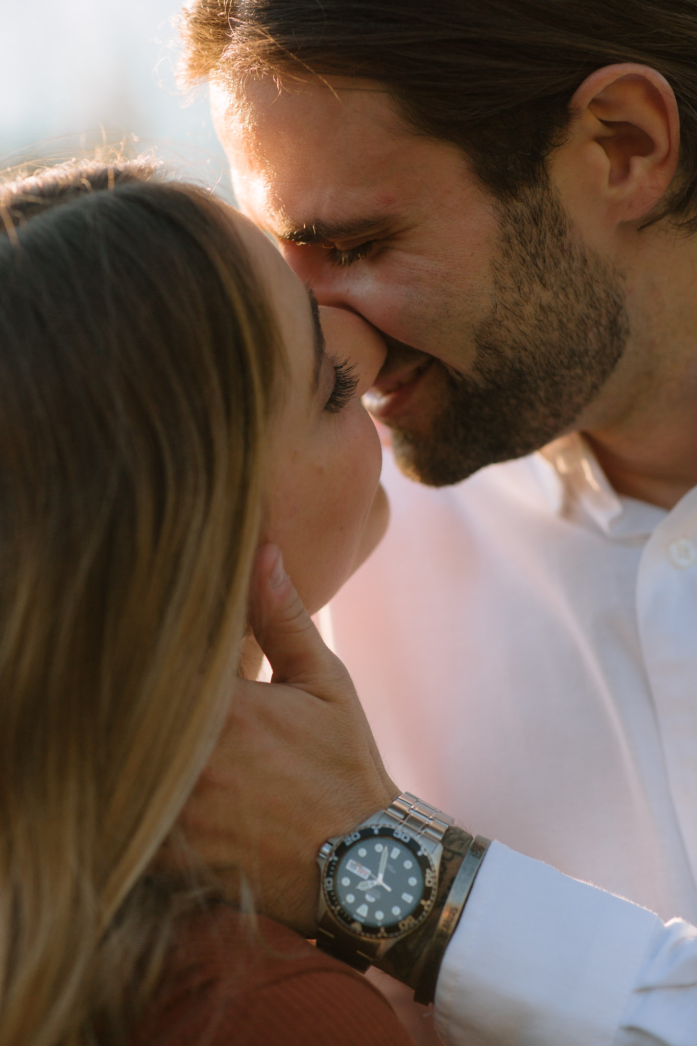 Detail focused wedding and engagement photography - close up image of partners with their lips together, laughing