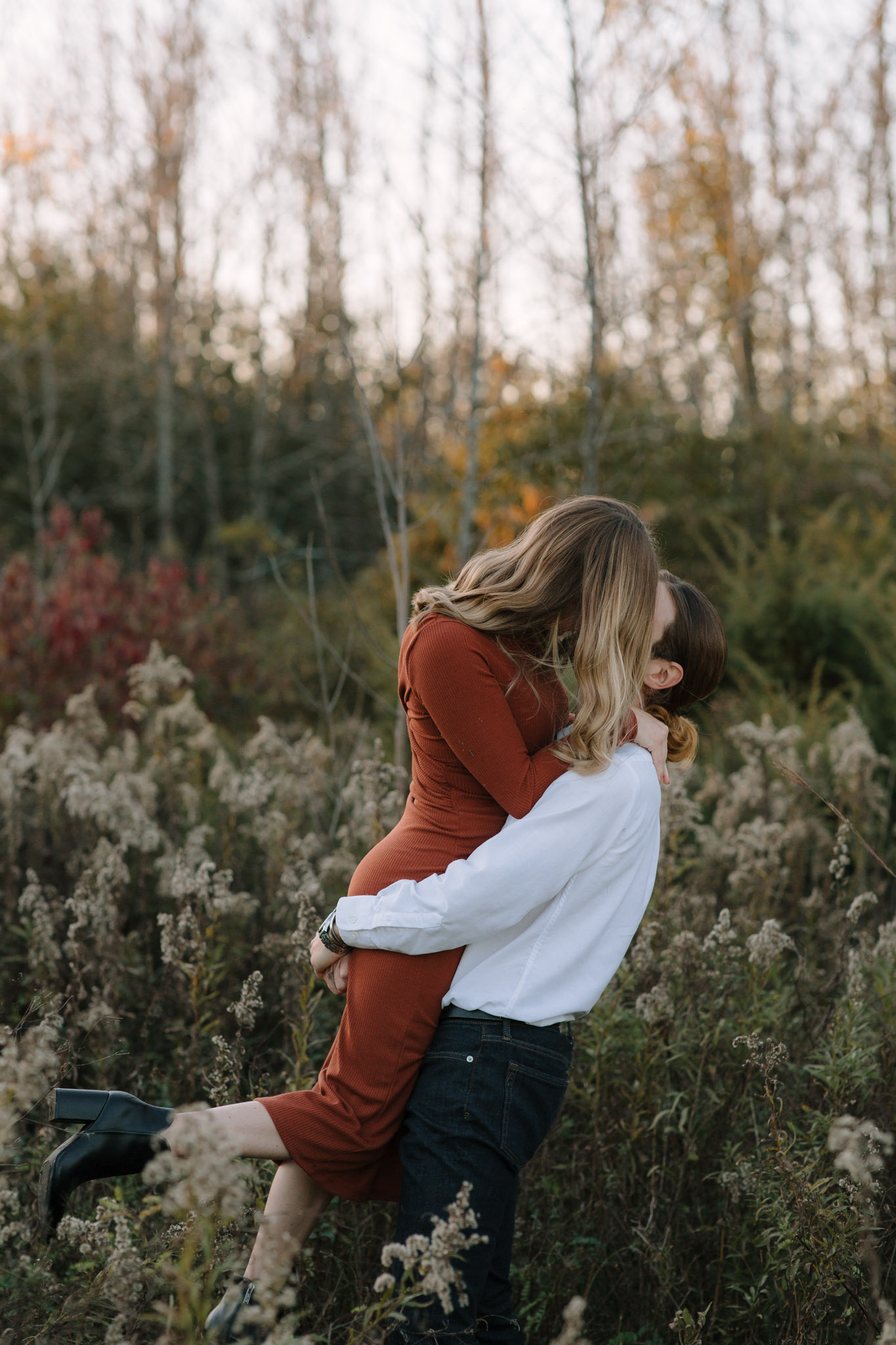 Motion based engagement photography in Milwaukee Wisconsin - man swinging his partner around as she kicks up her feet