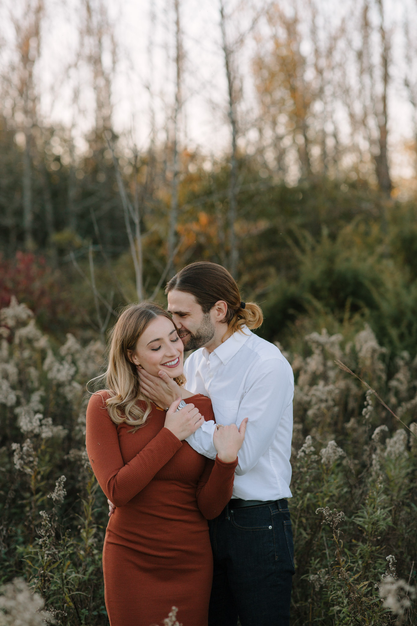 Engagement session with motion - man whispering into partner's ear making her laugh