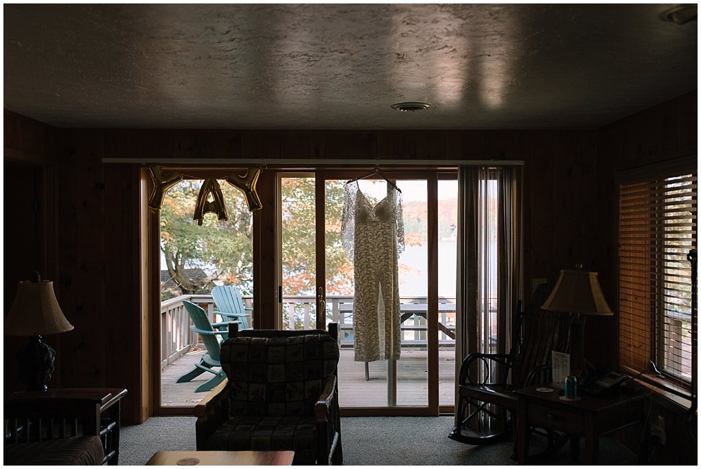 Grace Loves Lace wedding dress hanging in cabin - unique camp wedding inspiration