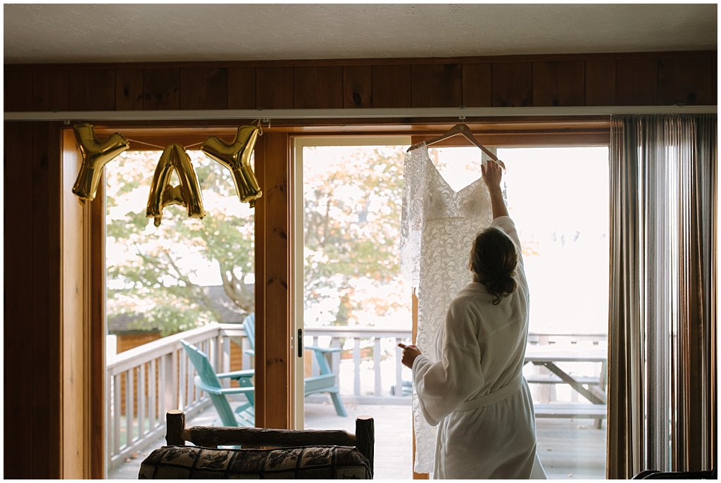 Bride hanging up dress - camp wedding