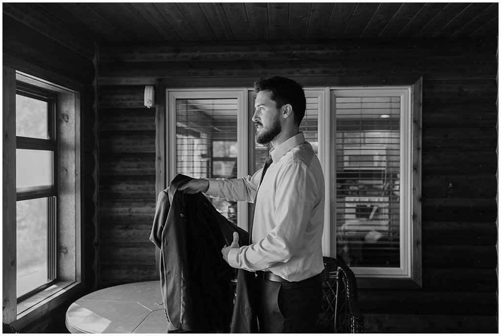 Groom putting on jacket