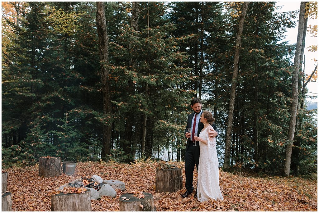 Wedding photos around a campfire with log chairs - unique camp wedding inspiration in Northwoods of Wisconsin 
