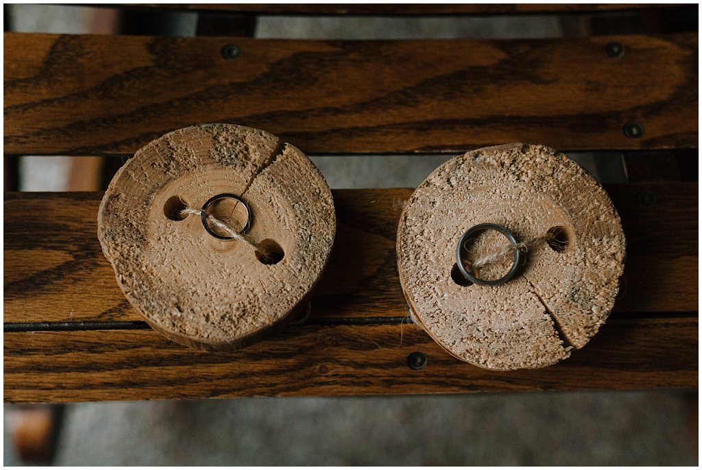 wedding rings tied to log coasters for ceremony - unique camp wedding inspo