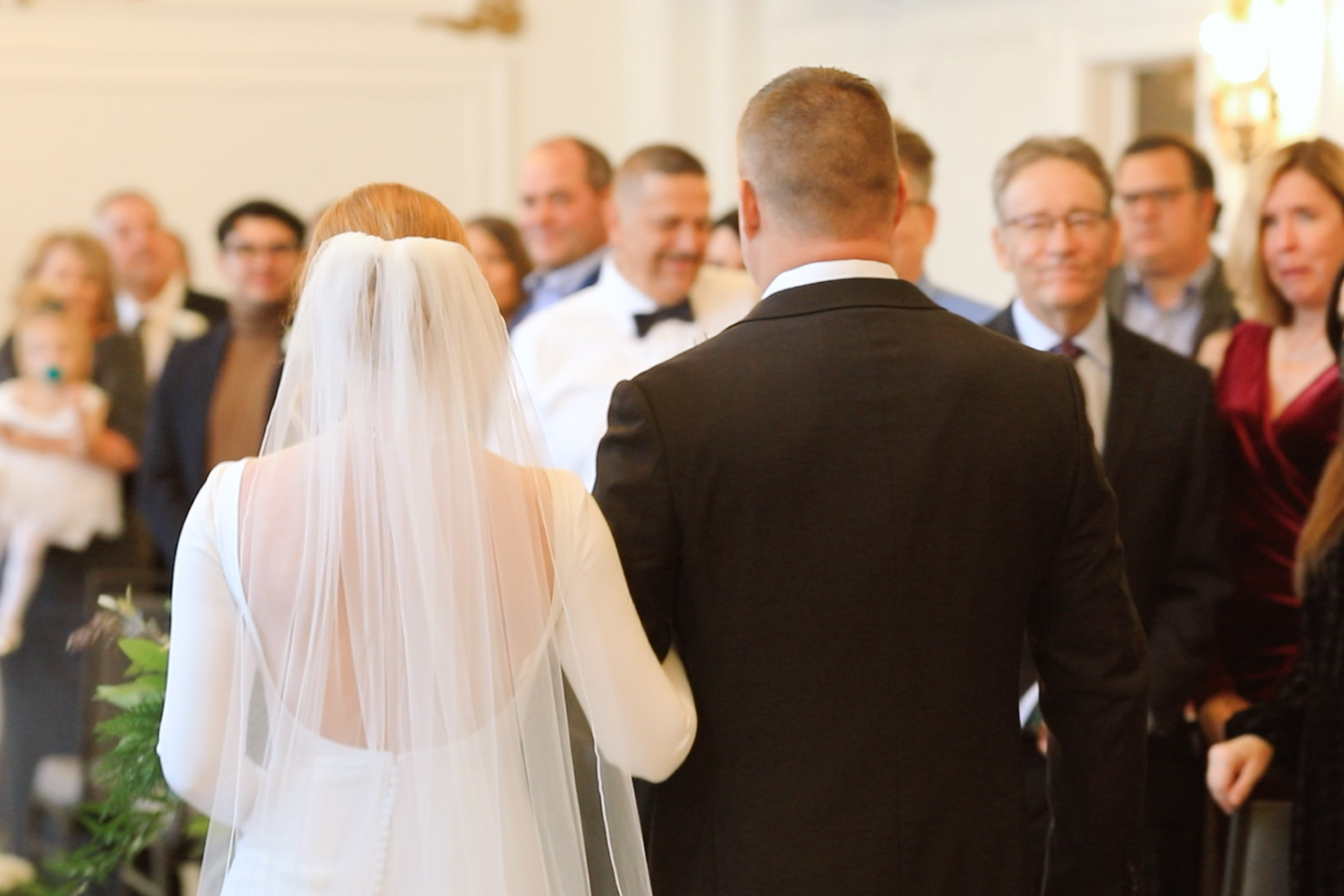 Bride's back as she is walking down the aisle