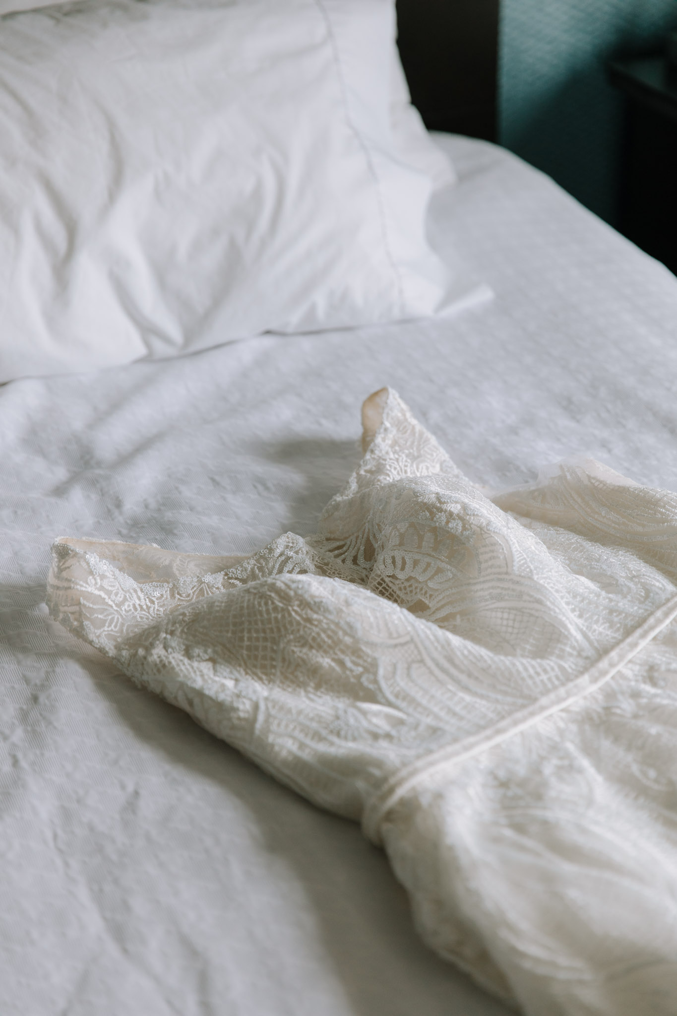 Fine art wedding photo - lace wedding gown on bed before St Stanislaus wedding - Hilton Homewood Suites - Wauwatosa