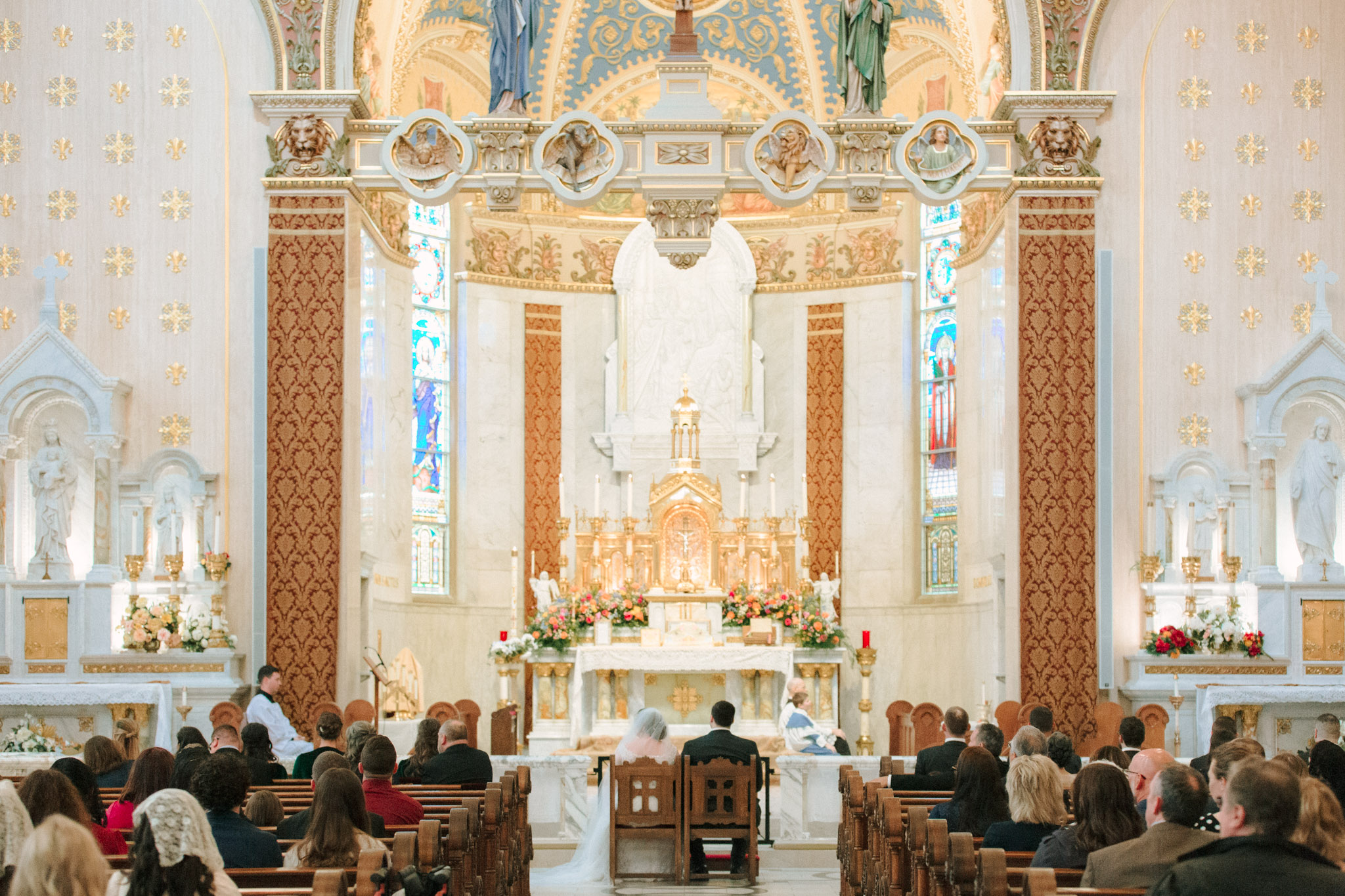 Bride and groom sitting during wedding ceremony at St Stanislaus