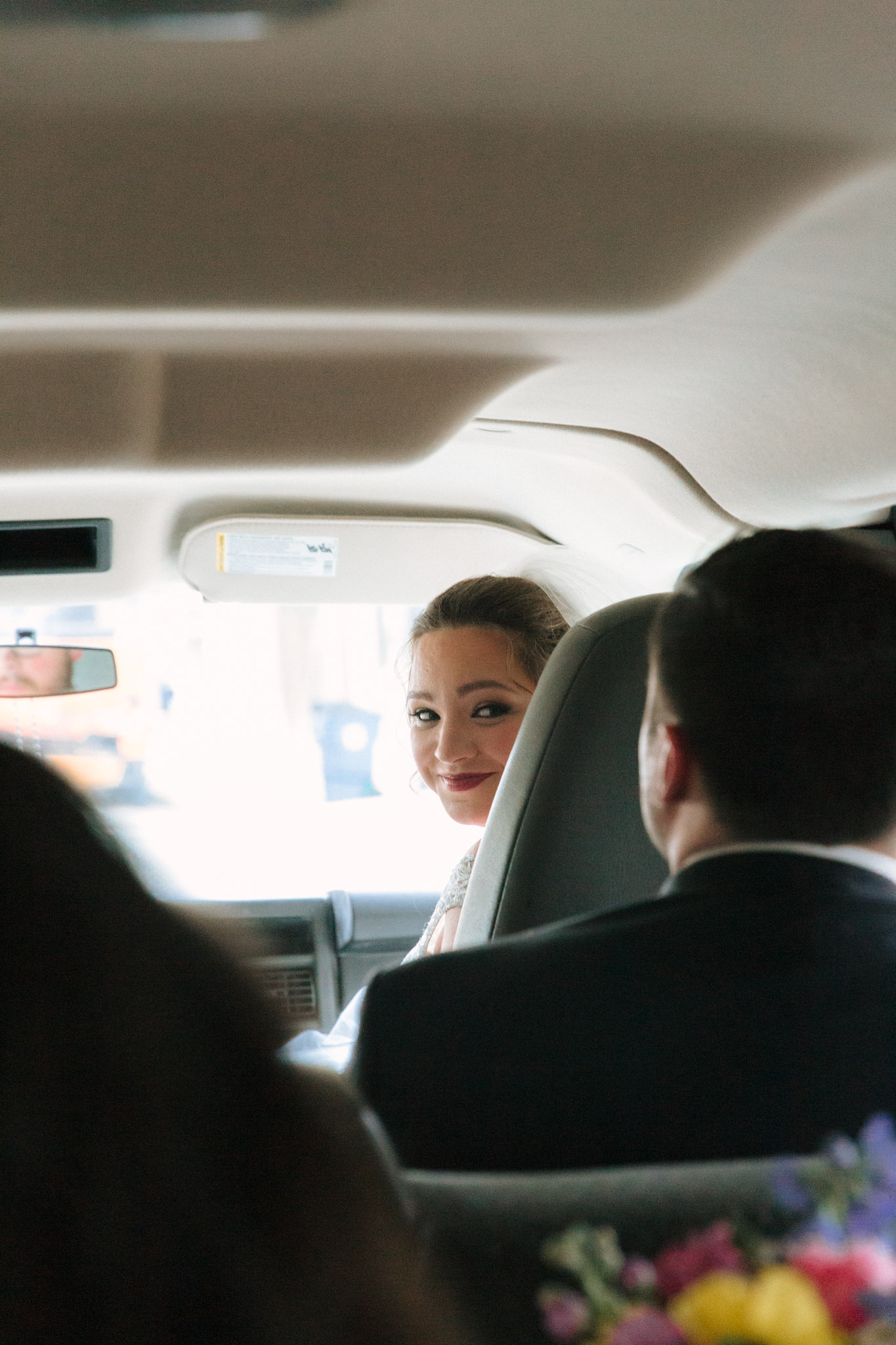 Bride and groom in car driving to Pabst Theatre for wedding photos