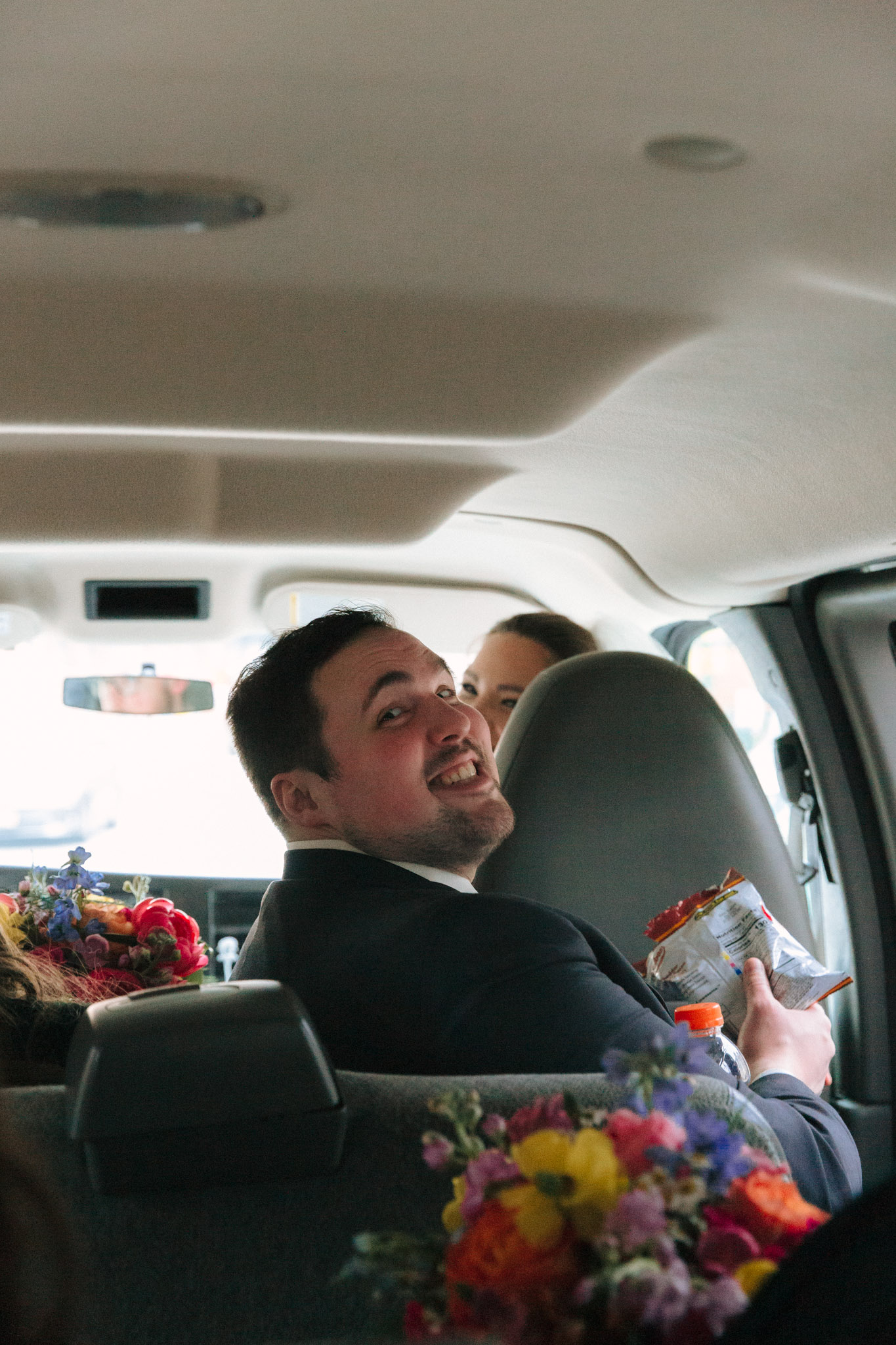 Bride and groom in car driving to Pabst Theatre for wedding photos