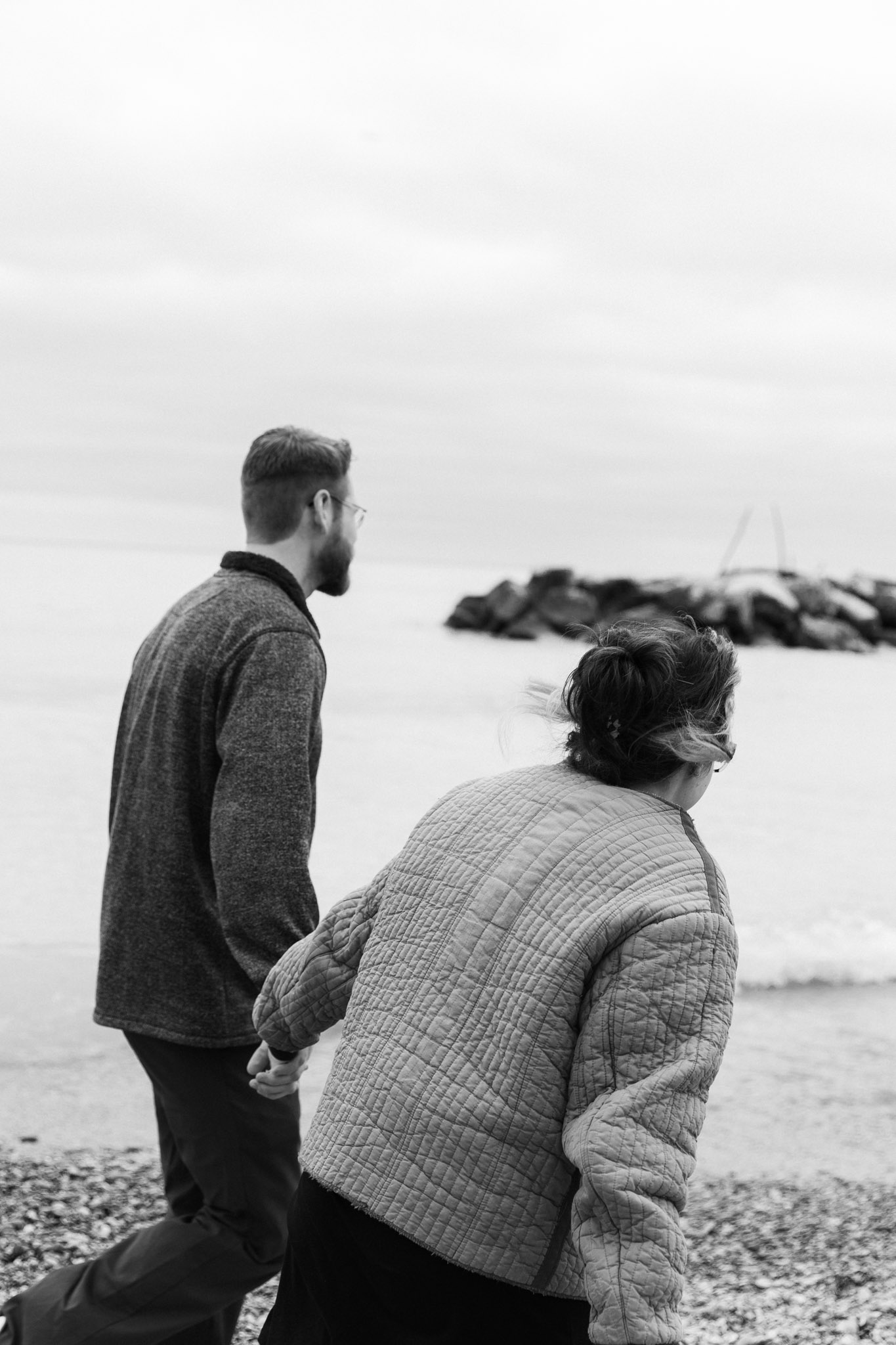Couple running along the lake - Klode Park Milwaukee Wisconsin Lake Engagement