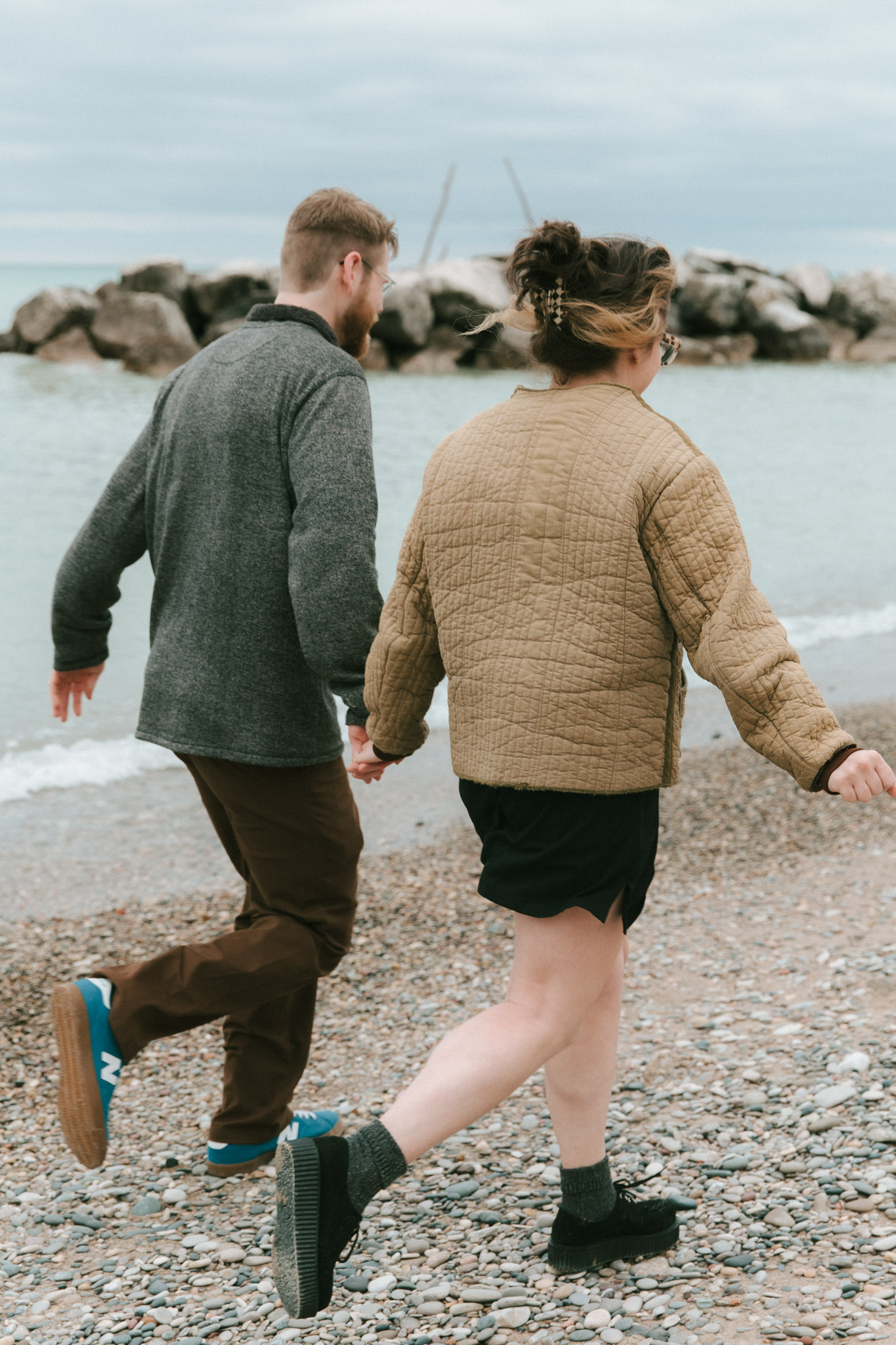 Couple running along the lake - Klode Park Milwaukee Wisconsin Lake Engagement
