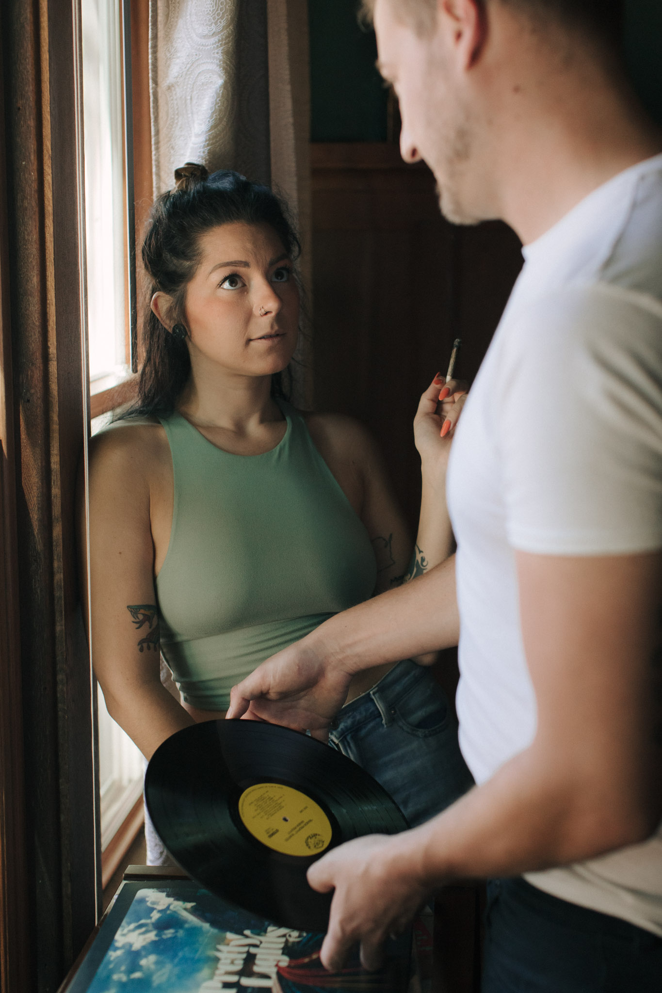 Retro 1960s inspired engagement photos with a blunt, record player, and guitar