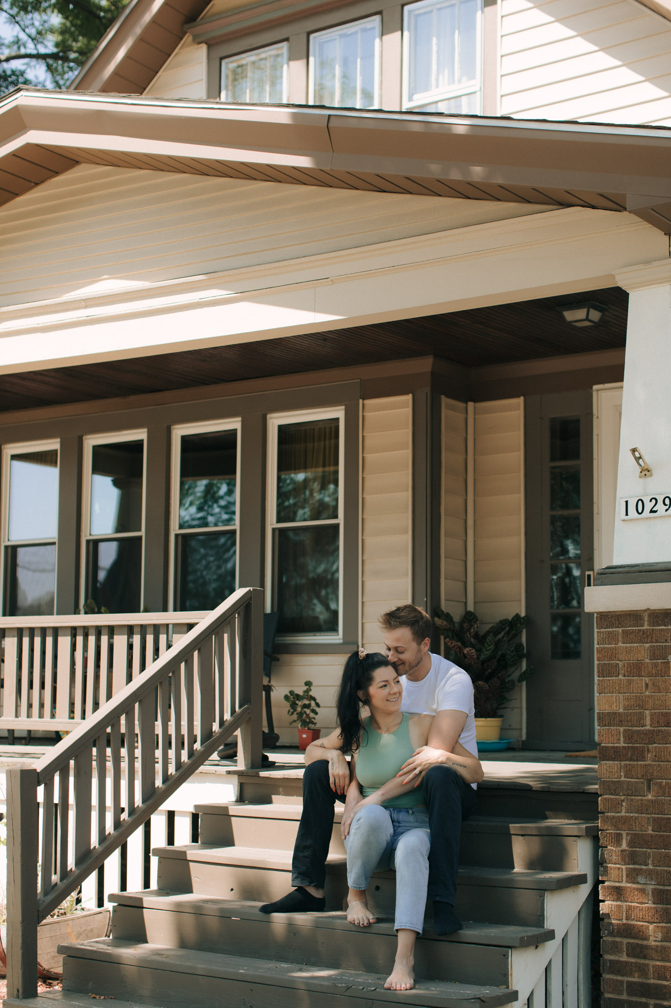 Milwaukee engagement photographers Kayla Hurst from Emerald Tide Photography sitting on her porch with her fiance