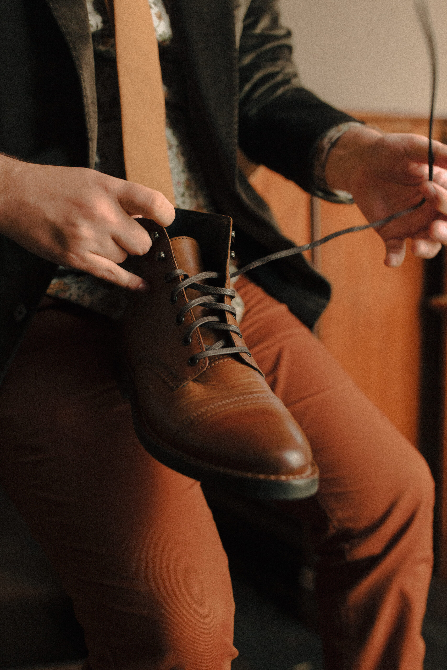 Groom untying vintage wedding boots