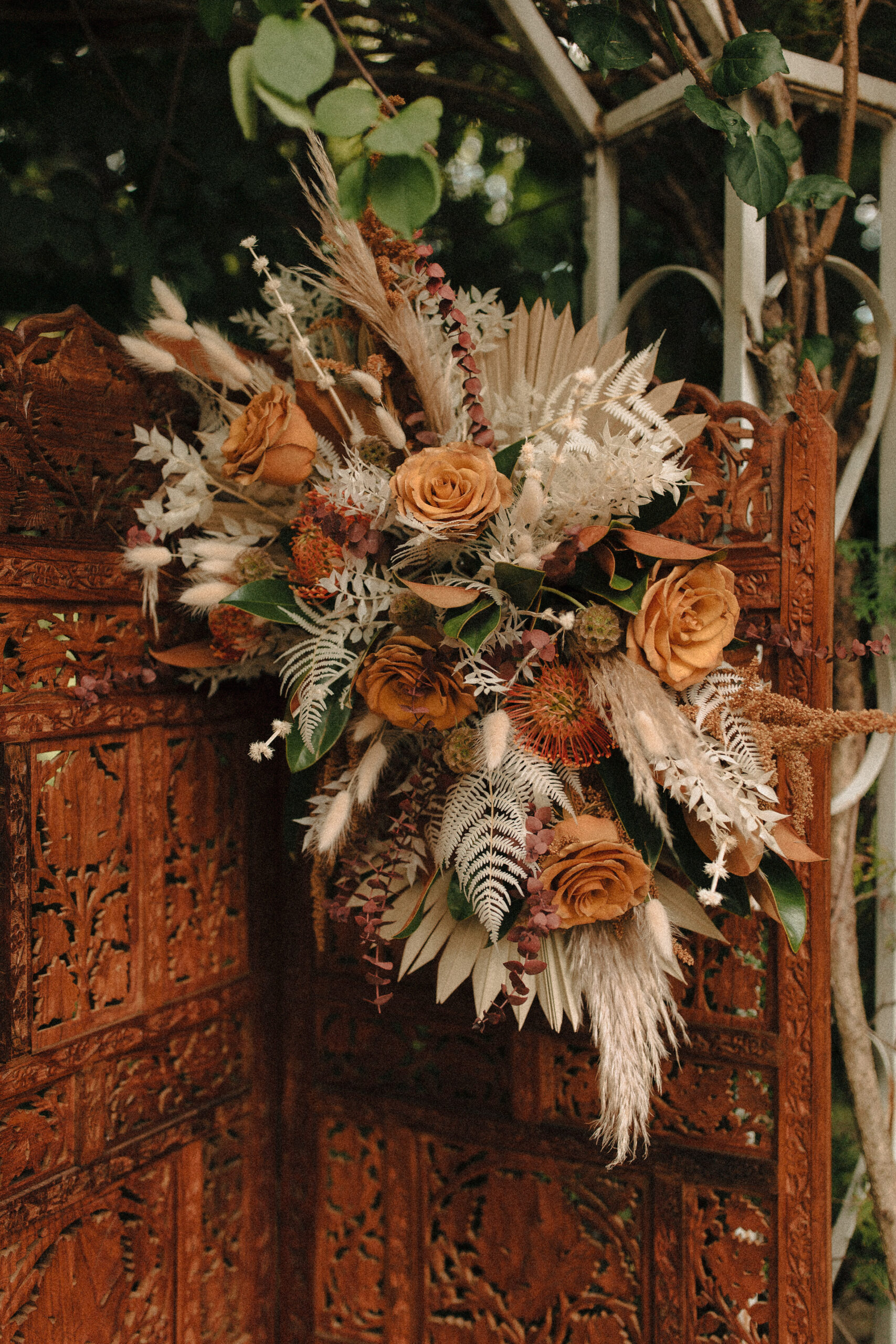 victorian revival romantic wedding ceremony altar with boho flowers and upholstered chairs